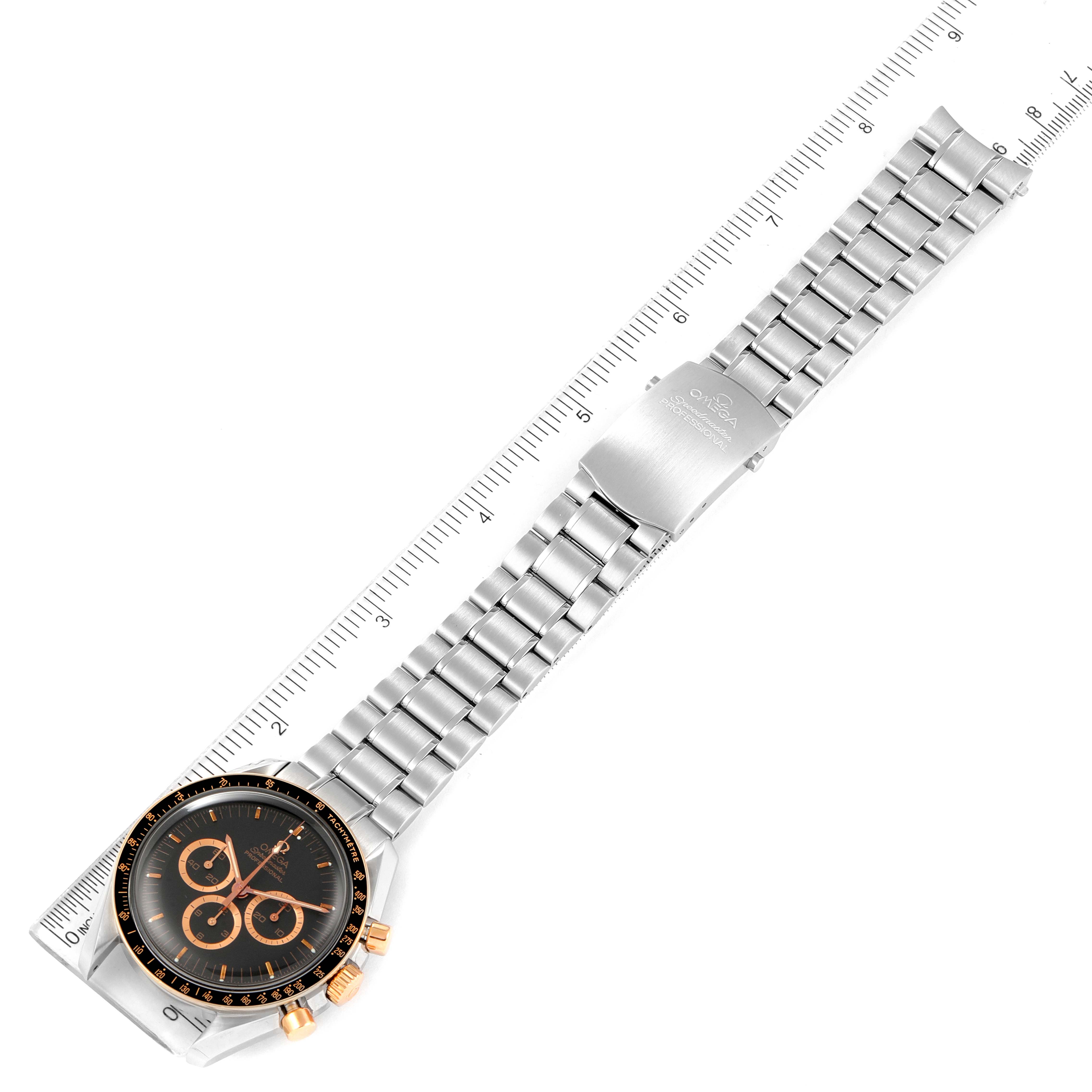 The Omega Speedmaster 3366.51.00 Men's Steel and Gold (two tone) Black Dial 3366.51.00 Men's Steel and Gold (two tone) Black Dial watch is shown from a top-down angle, displaying its face, bracelet, and clasp against a ruler for scale.
