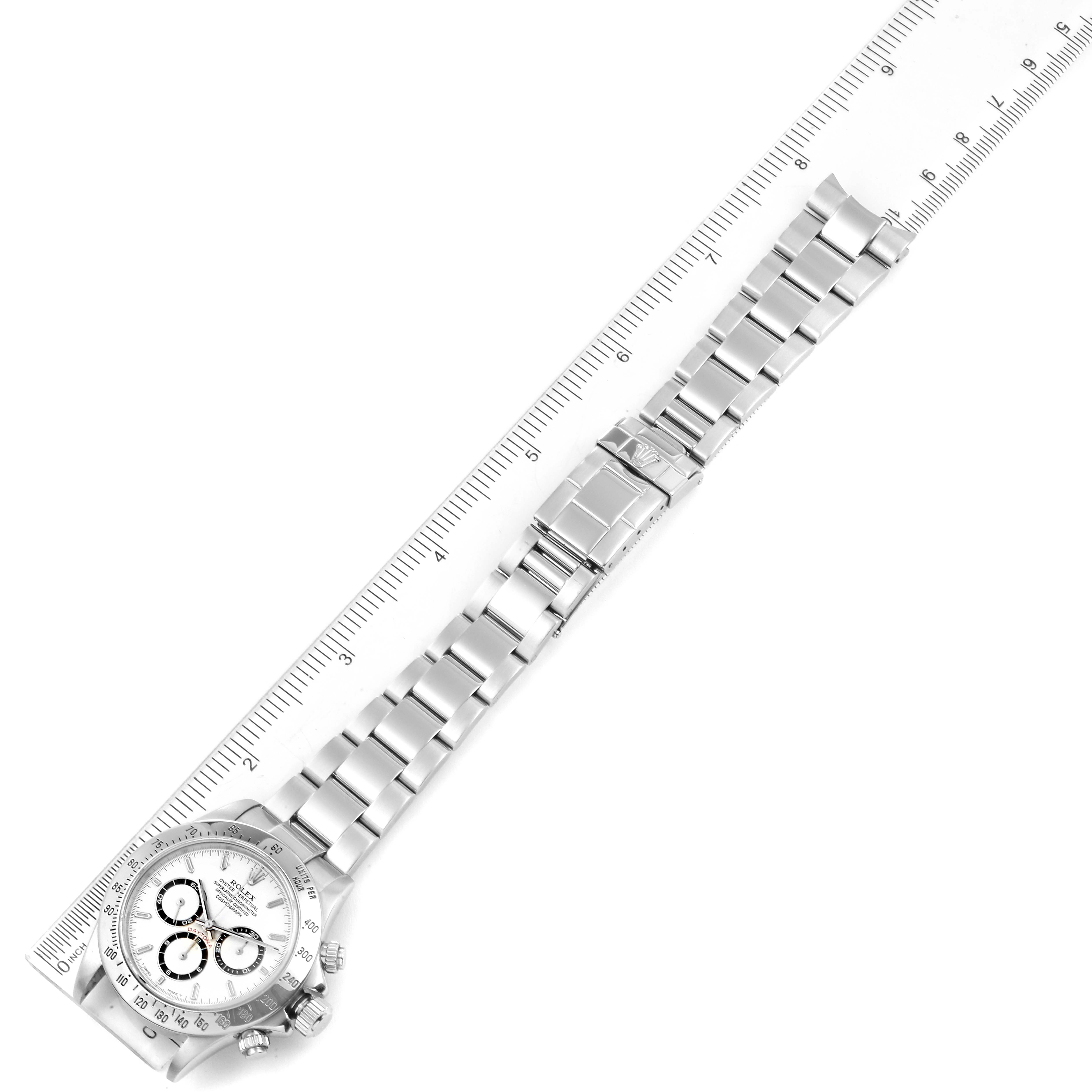 The image shows a top-down view of the Rolex Daytona 16520 Men's Stainless Steel White Dial 16520 Men's Stainless Steel White Dial watch, with the full watch and band displayed alongside a ruler for scale.