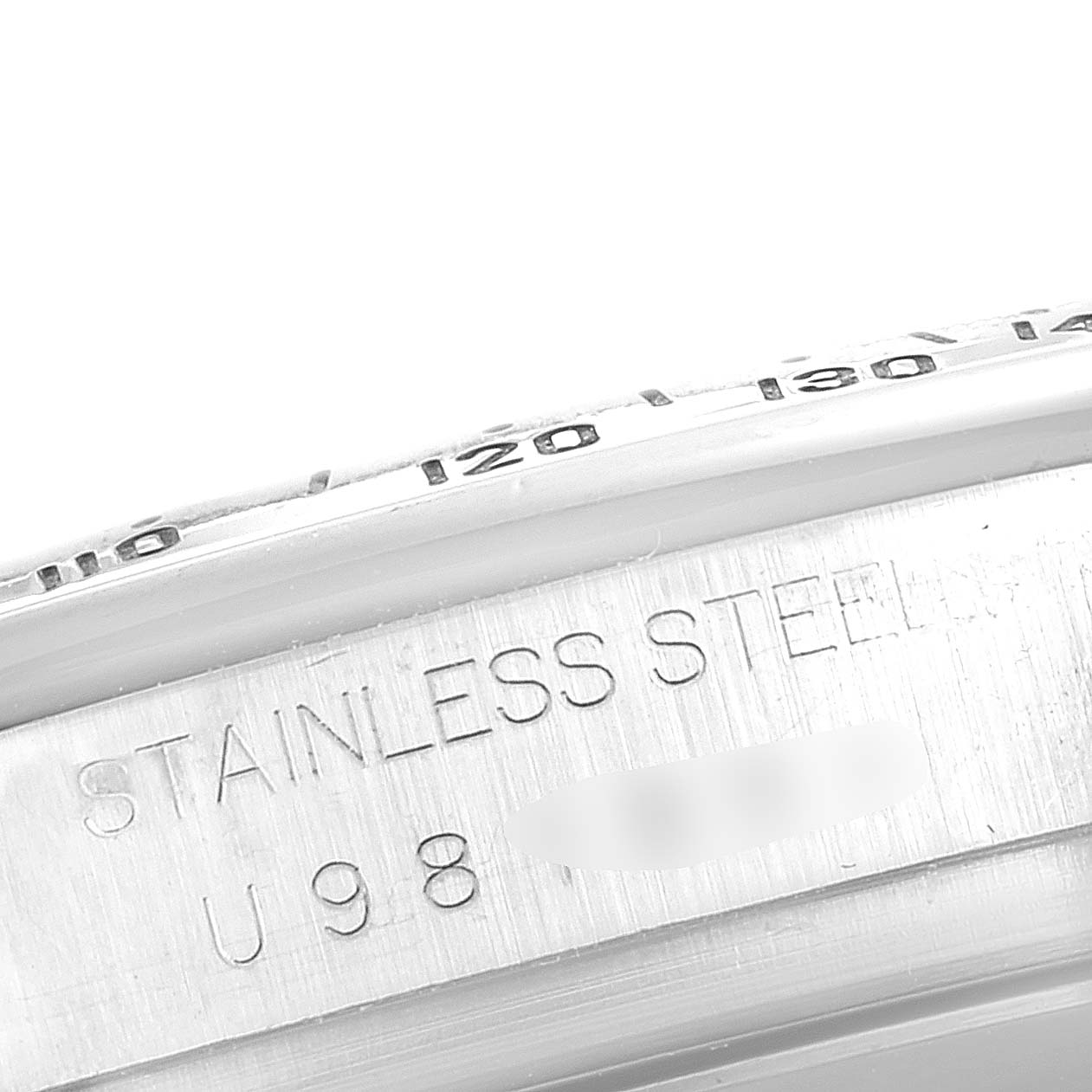 The image shows a close-up of the side and part of the bezel of a Rolex Daytona 16520 Men's Stainless Steel White Dial 16520 Men's Stainless Steel White Dial watch, highlighting the "STAINLESS STEEL" engraving.