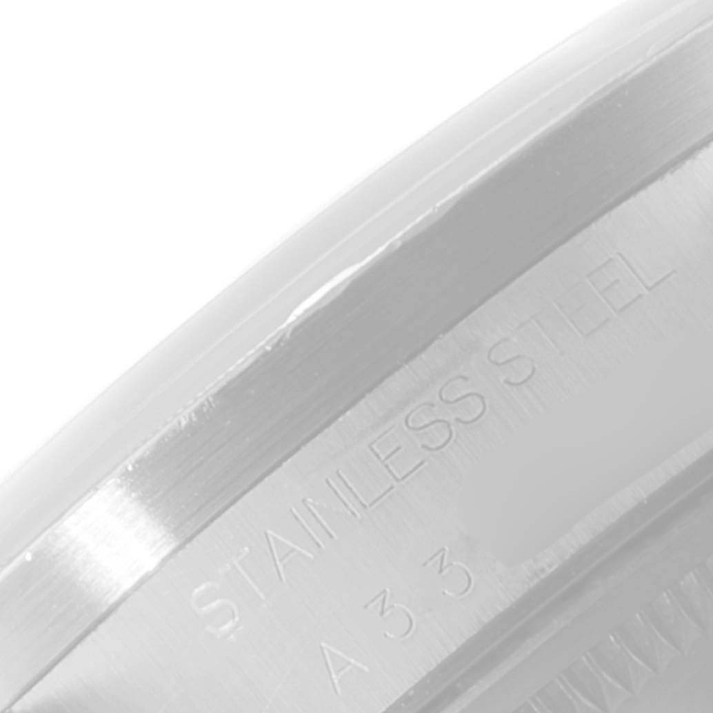 This image shows an up-close view of the side of a stainless steel Rolex Date 15210 Men's Stainless Steel Black Dial 15210 Men's Stainless Steel Black Dial model watch case, highlighting the engraved lettering.