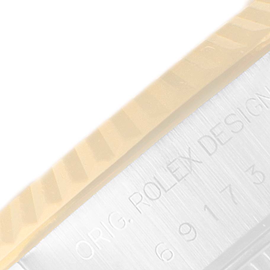 This close-up image shows part of the bezel and the edge of the case with engraved text of the Rolex Datejust 69173 Women
s Steel and Gold (two tone) Champagne Dial 69173 Women
s Steel and Gold (two tone) Champagne Dial watch.