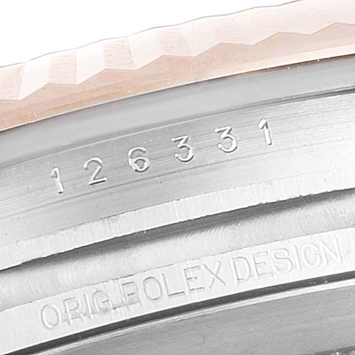 This image shows the serial number and part of the fluted bezel of a Rolex Datejust 41 126331 Men's Steel and Gold (two tone) Silver Dial 126331 Men's Steel and Gold (two tone) Silver Dial watch.