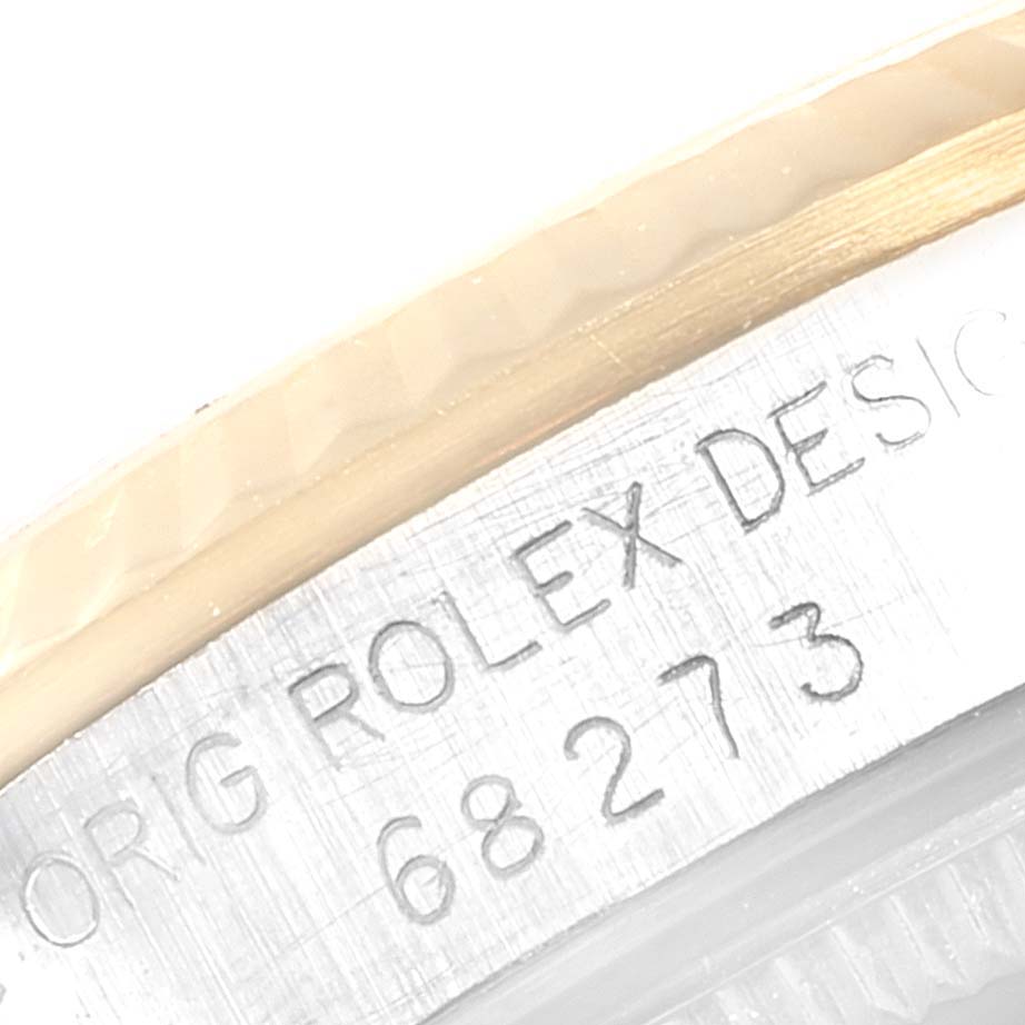 The image shows a close-up of the serial number and engraving on the metal case side of a Rolex Mid-Size 68273 Women
s Steel and Gold (two tone) White Dial 68273 Women
s Steel and Gold (two tone) White Dial model watch.