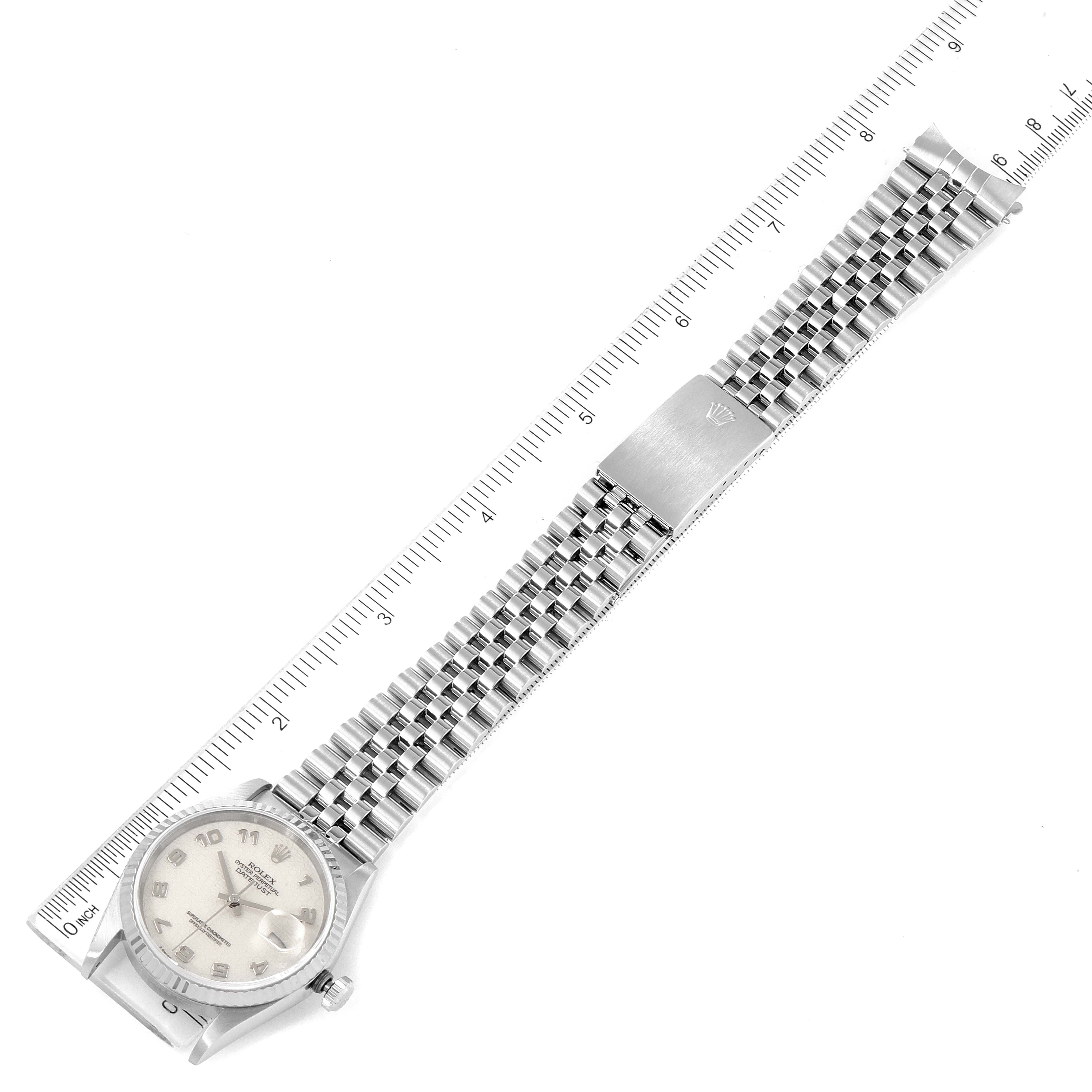 The Rolex Datejust 16234 Men's Stainless Steel Silver Dial 16234 Men's Stainless Steel Silver Dial watch is shown flat with its face, bracelet, and clasp visible, alongside a measuring ruler.