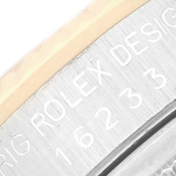 The image shows a close-up of the bezel and edge of the case for a Rolex Datejust 16233 Men's Steel and Gold (two tone) Champagne Dial watch, highlighting engraved text and numbers.