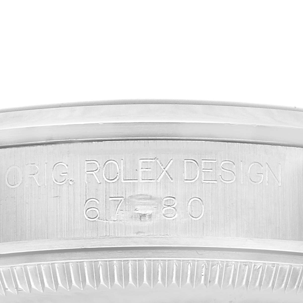 The image shows a close-up of the side with engraved markings on a Mid-Size Rolex watch.