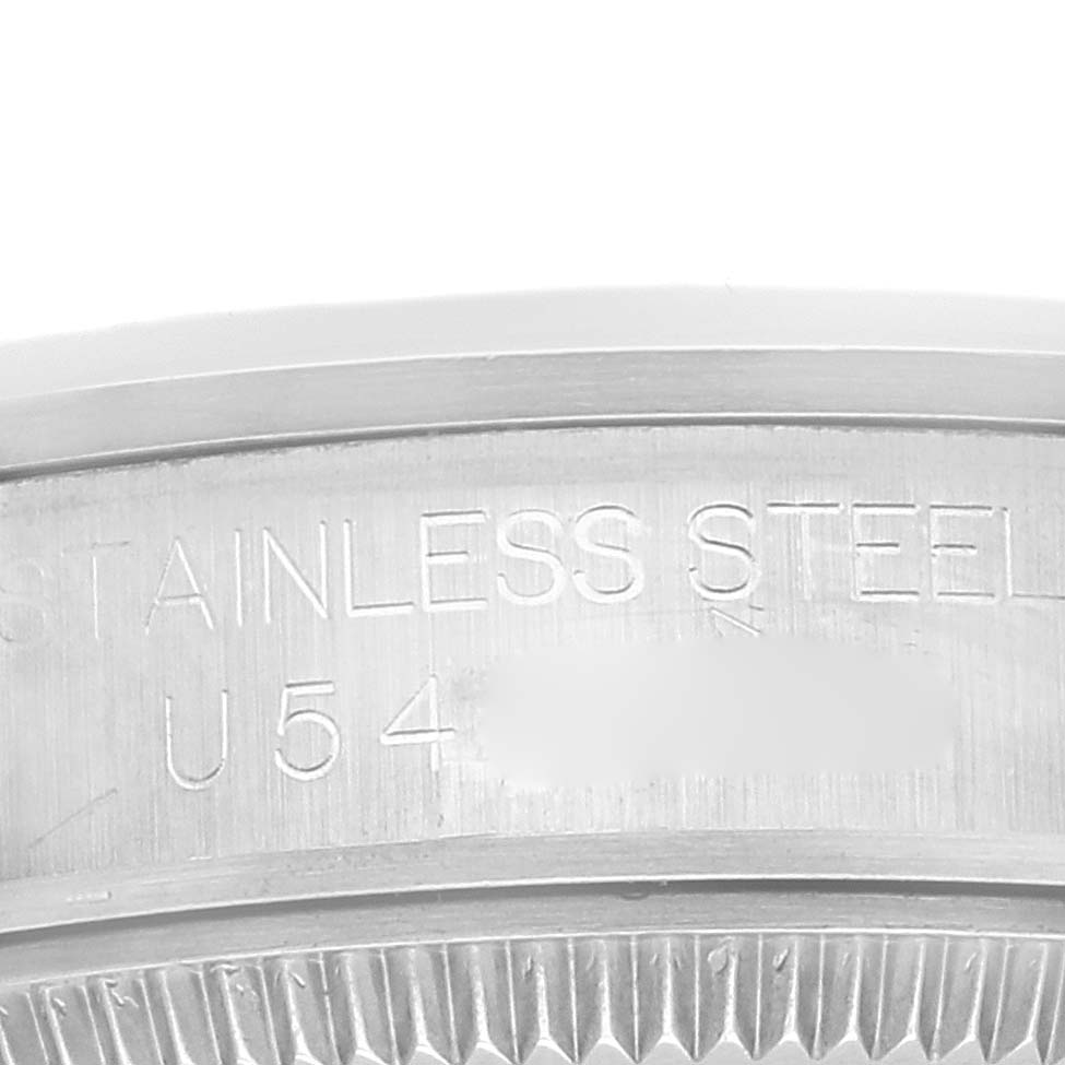 The image shows a close-up angle of the Rolex Mid-Size 67480 Women
s Stainless Steel Silver Dial 67480 Women
s Stainless Steel Silver Dial watch case back, displaying its stainless steel material and partial serial number.