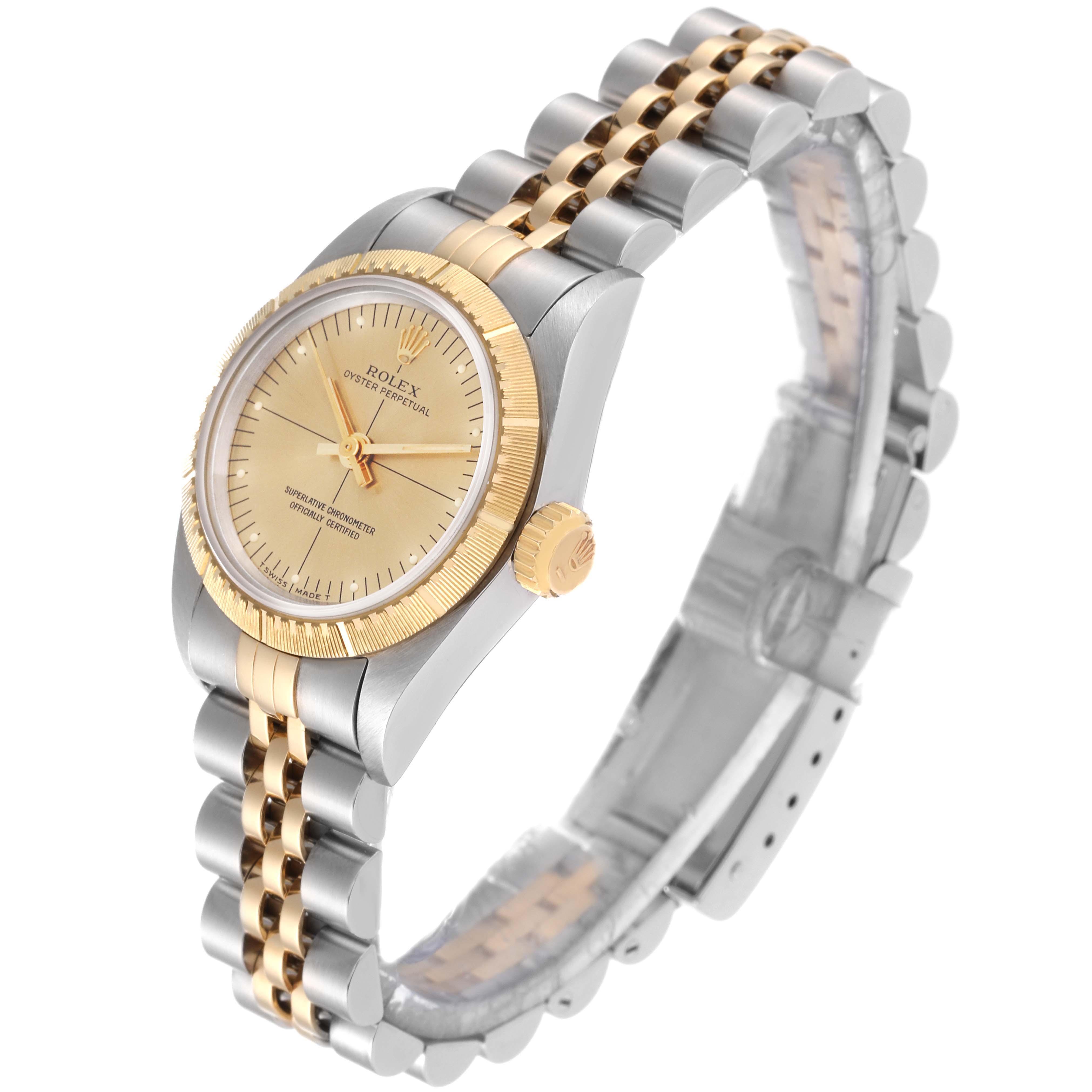 This image shows a Rolex Oyster Perpetual 67243 Women's Steel and Gold (two tone) Champagne Dial 67243 Women's Steel and Gold (two tone) Champagne Dial watch, highlighting its gold bezel, crown, and two-tone steel and gold bracelet from a side angle.