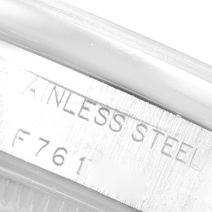 The image shows an engraving on the side of a stainless steel Rolex Oyster Perpetual 76080 Women
s Stainless Steel Pink Dial 76080 Women
s Stainless Steel Pink Dial watch case.