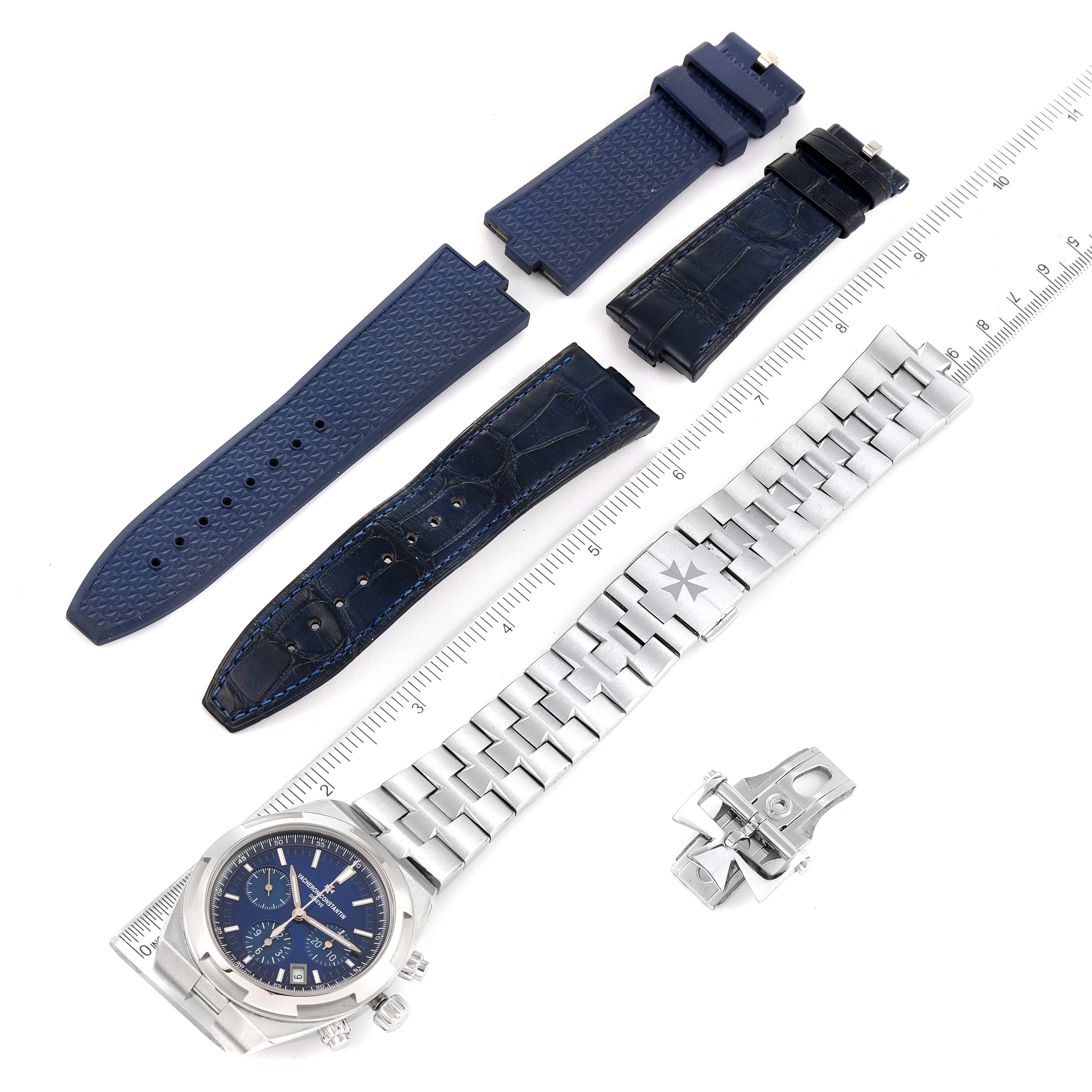 The image shows a Vacheron Constantin Overseas 5500V/110A-B148 Men's Stainless Steel Blue Dial 5500V/110A-B148 Men's Stainless Steel Blue Dial watch and its accessories, including interchangeable blue and leather straps, a metal bracelet, and a clasp.
