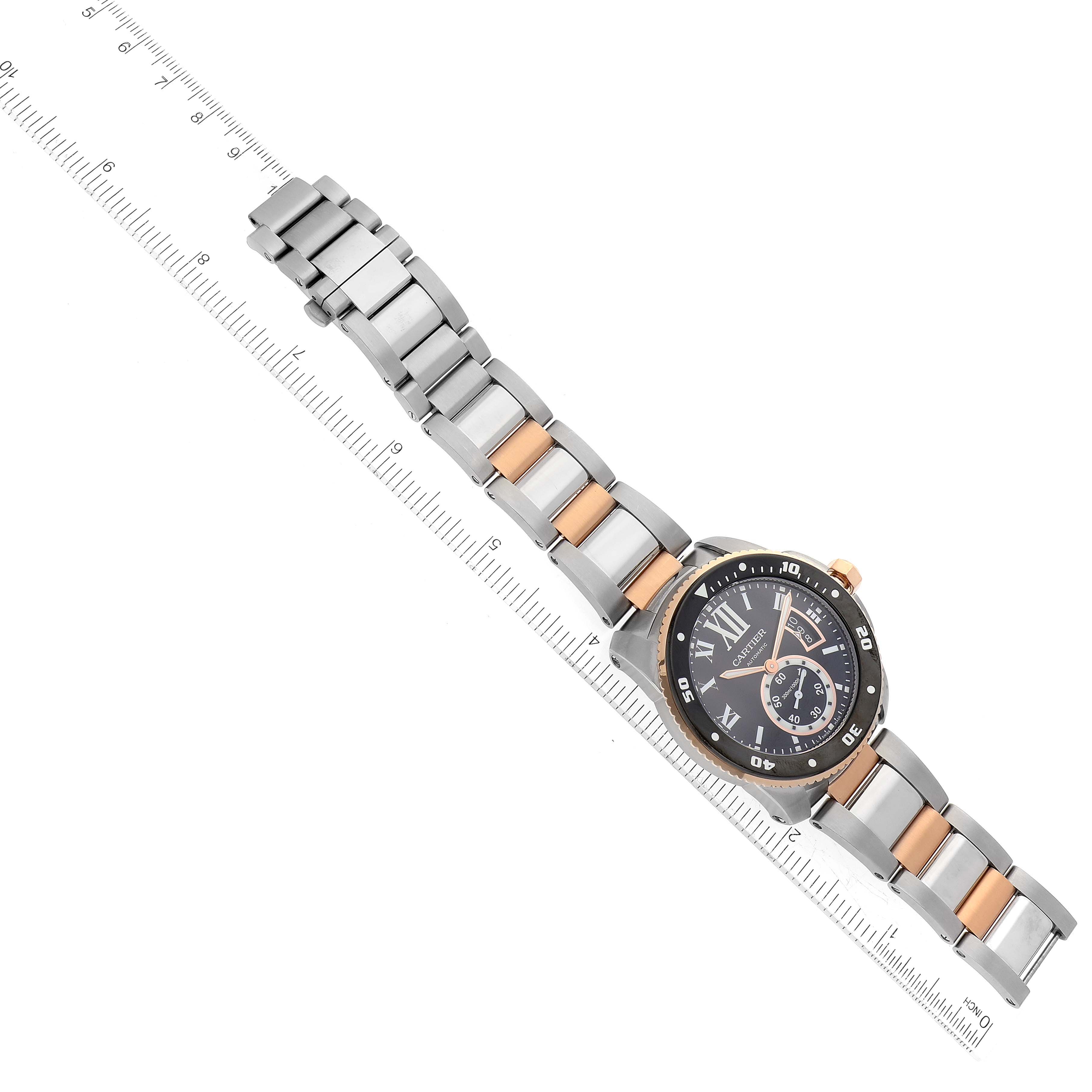 The angled photo shows the entire Calibre de Cartier watch by Cartier, including the watch face and the two-tone metal strap.