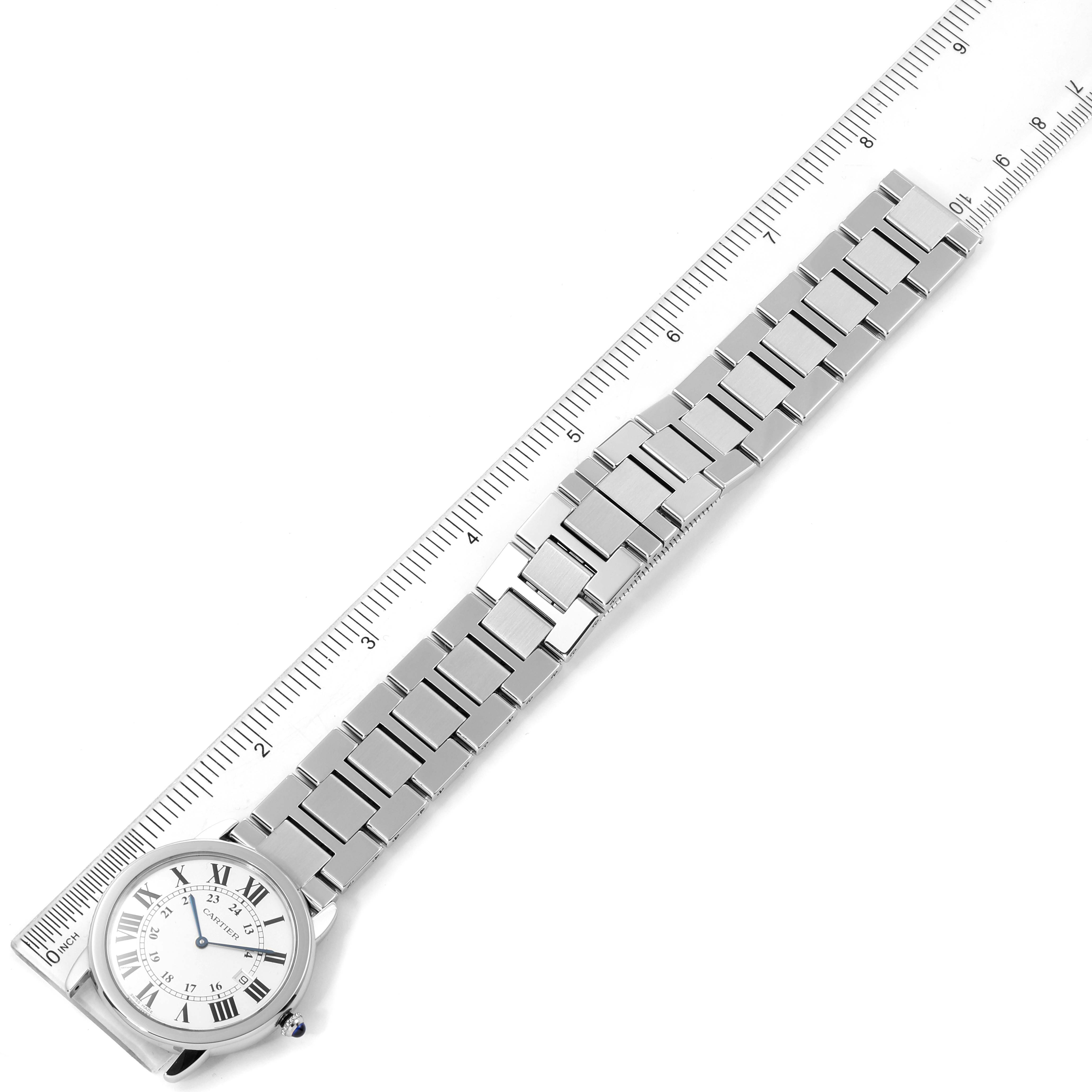 The image shows the Cartier Ronde W6701005 Men
s Stainless Steel Silver Dial W6701005 Men
s Stainless Steel Silver Dial model watch laying flat with a ruler alongside it, highlighting the watch face and bracelet.