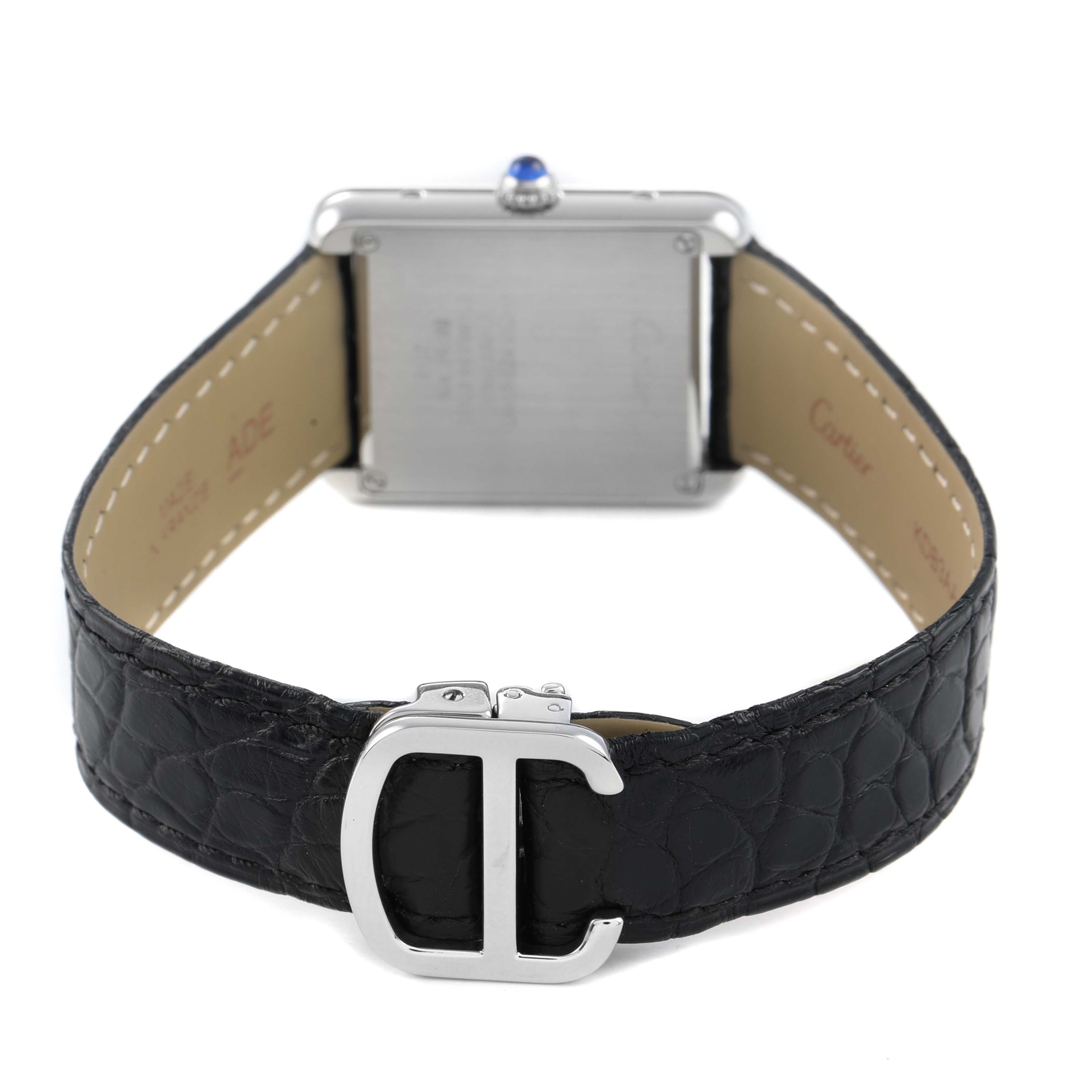 The image shows the back and clasp of a Cartier Tank Solo W1018255 Women's Stainless Steel Silver Dial watch with a visible leather strap and a crown with a blue cabochon.