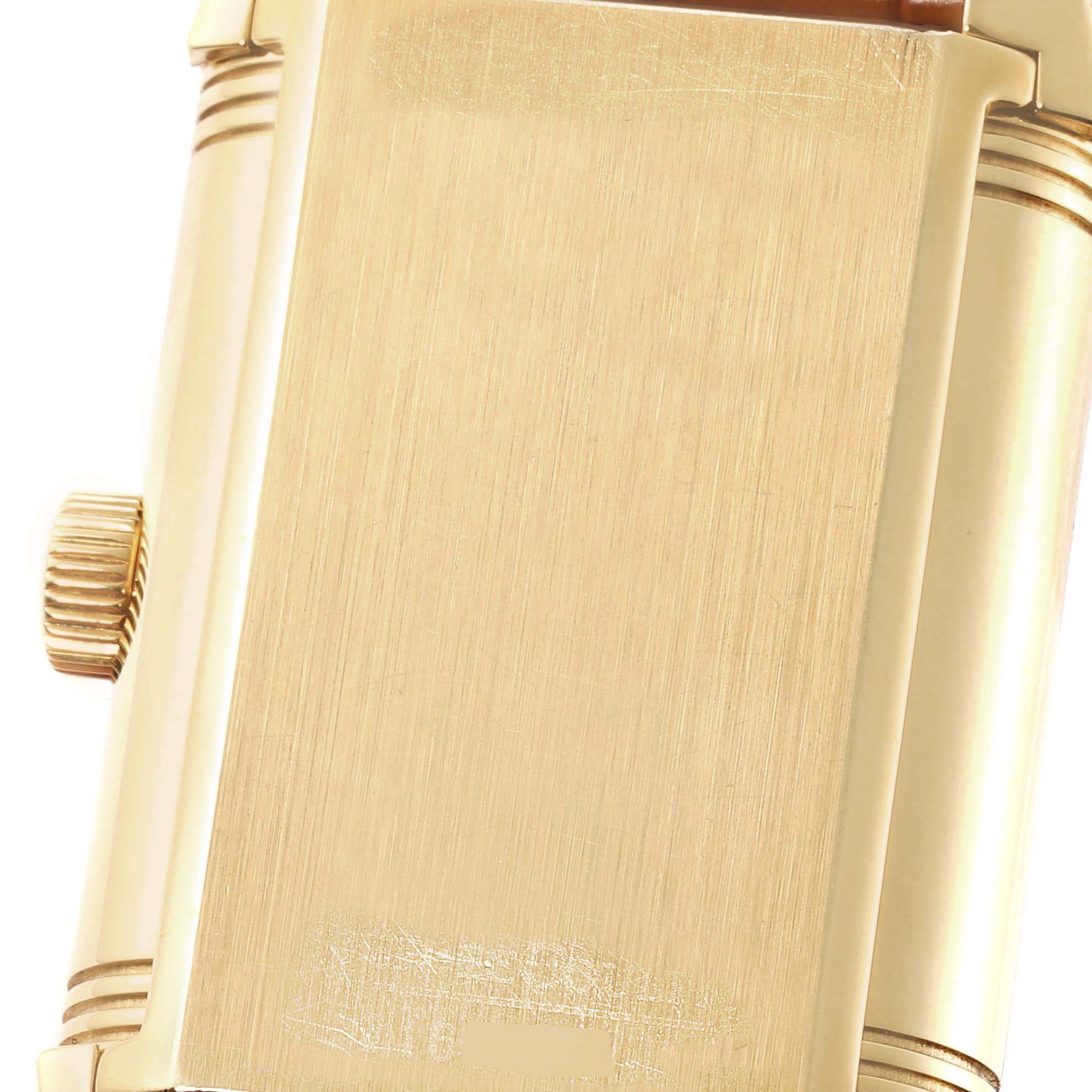 The image shows a close-up of the Jaeger-LeCoultre Reverso watch caseback, showcasing its gold finish and side crown.