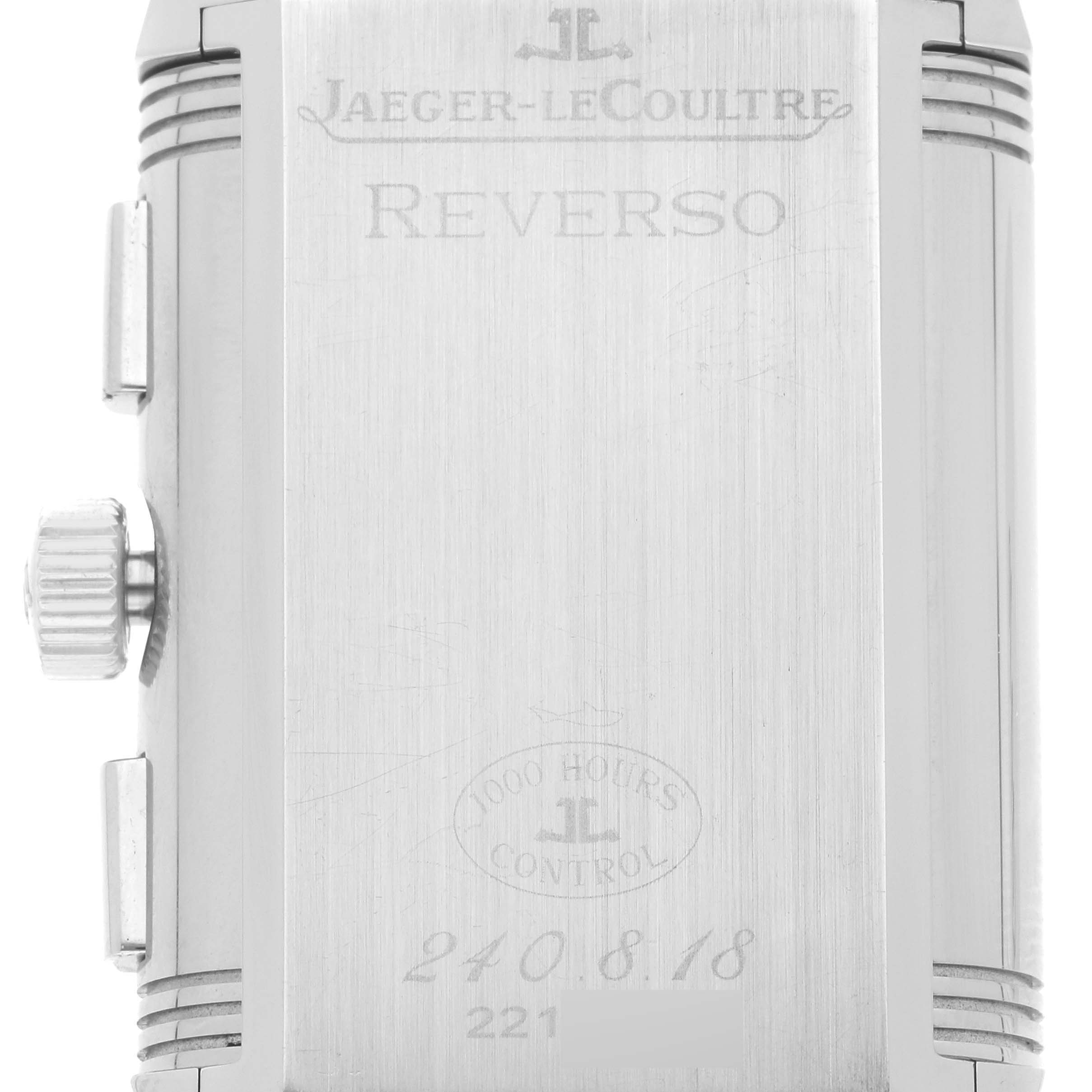 The image shows the back case of a Jaeger-LeCoultre Reverso watch, including the brand and model engravings.
