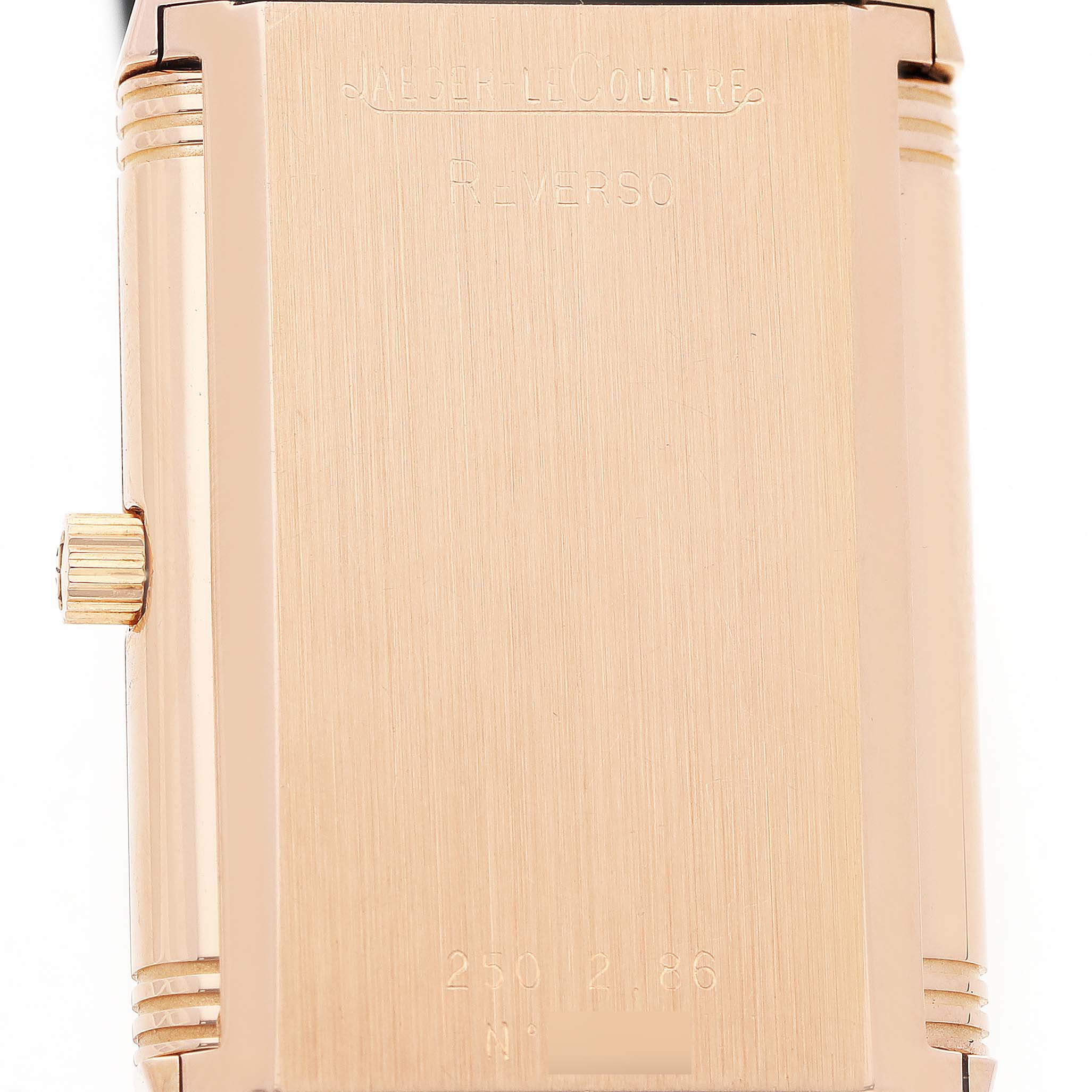 The image shows the back case of a Jaeger LeCoultre Reverso 250.2.86 Men's Rose Gold Black Dial watch, highlighting the engraved details and crown on the side.