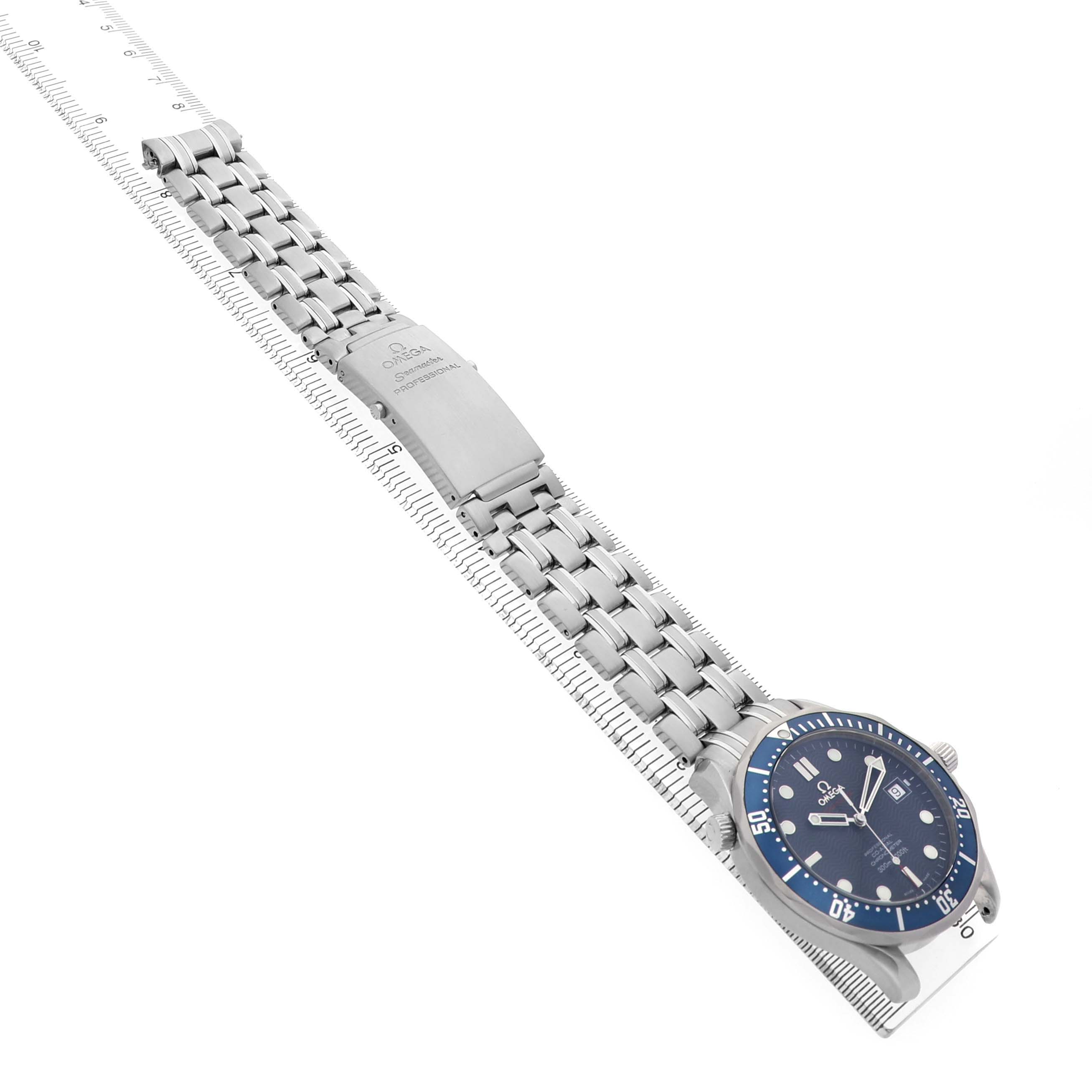 The Omega Seamaster 2220.80.00 Men's Stainless Steel Blue Dial watch is shown at an angle displaying its blue dial, bracelet, and clasp laid flat against a ruler.