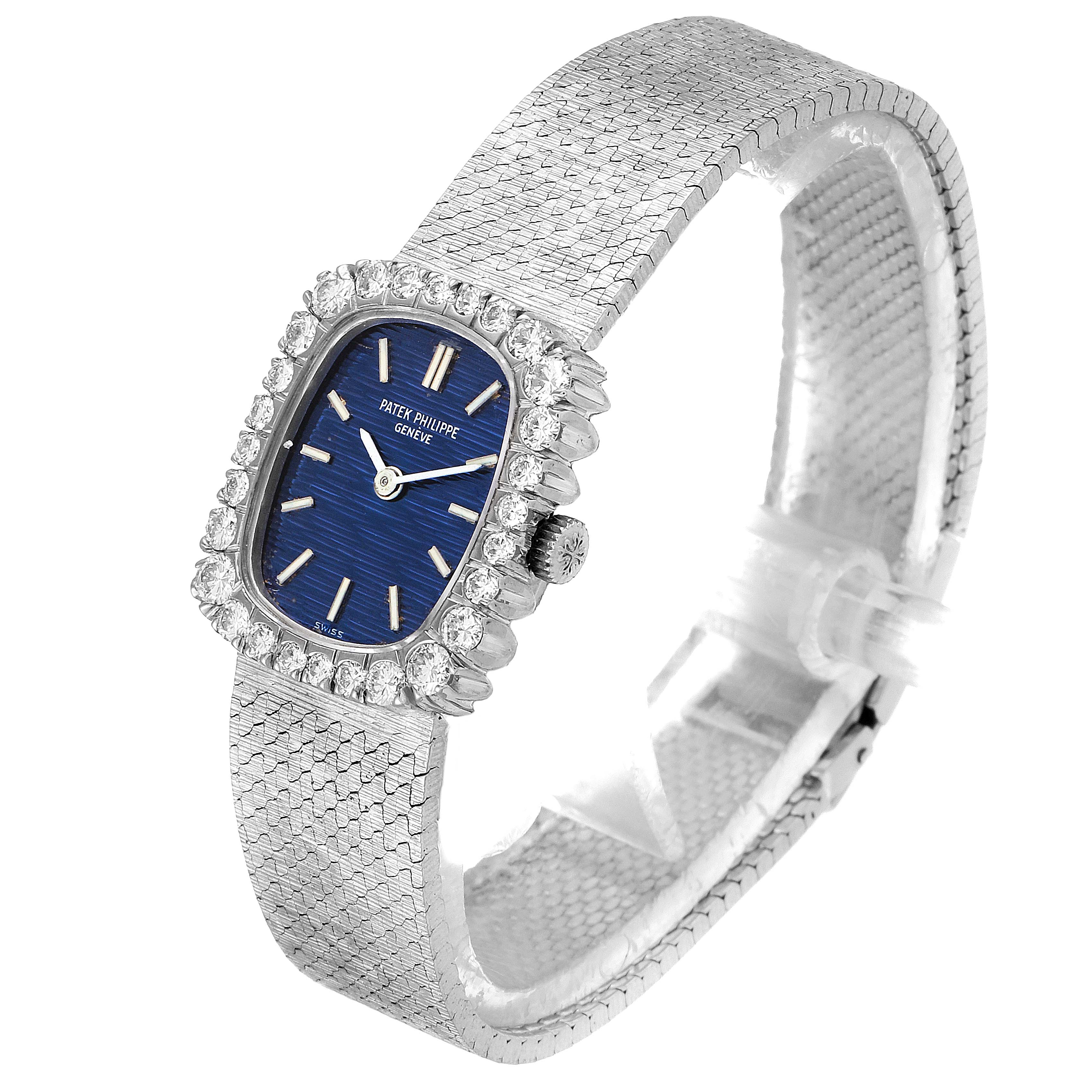 The Patek Philippe 4102 Women's White Gold Blue Dial 4102 Women's White Gold Blue Dial 4102 features a diamond bezel, blue dial, and white gold mesh bracelet, shown at a 3/4 angle.