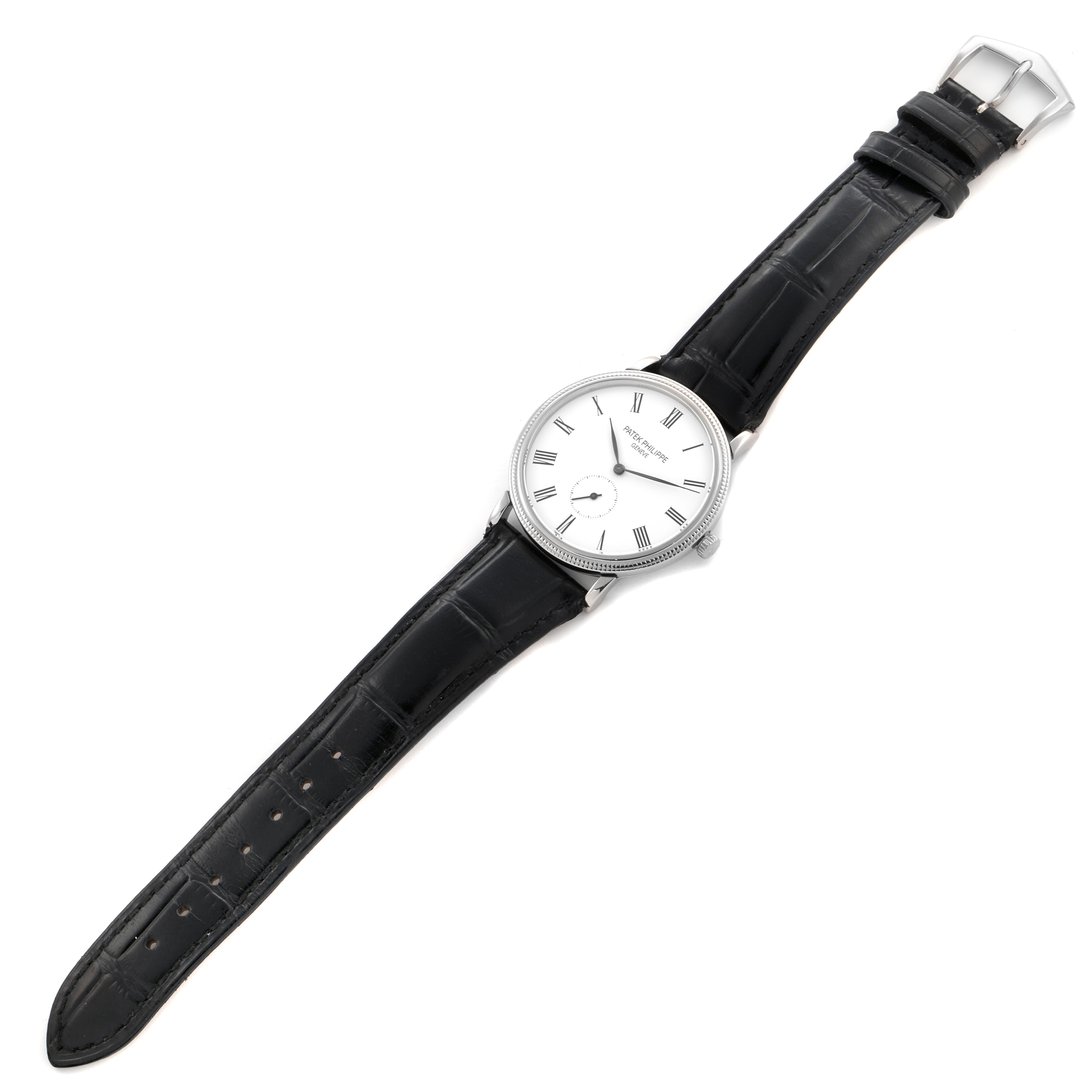 The Calatrava model by Patek Philippe is shown from a top view, displaying the watch face, bezel, strap, and buckle clearly.