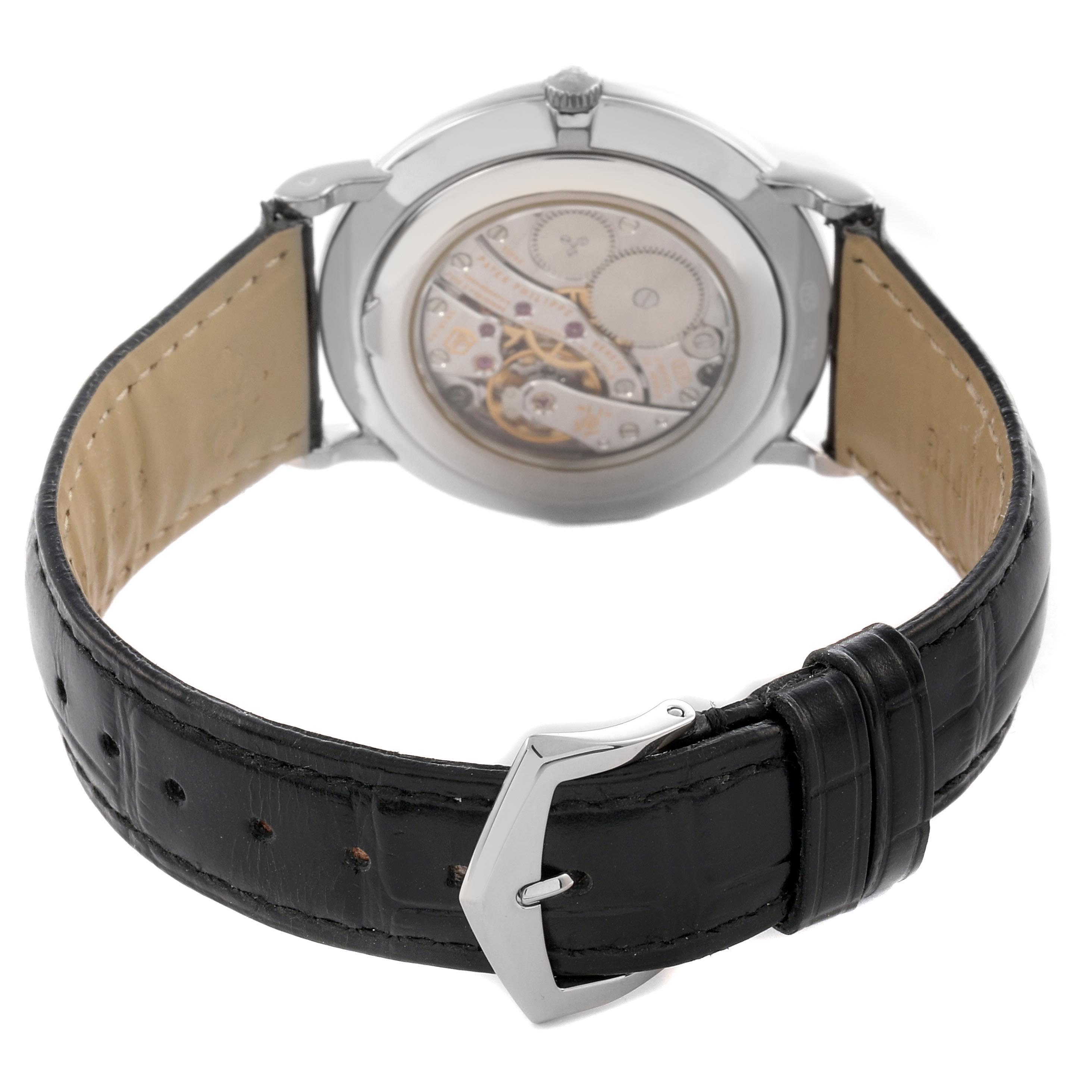 The image shows the back view of a Patek Philippe Calatrava 5119G-001 Men's White Gold White Dial 5119G-001 Men's White Gold White Dial watch, highlighting its movement and black leather strap with buckle.