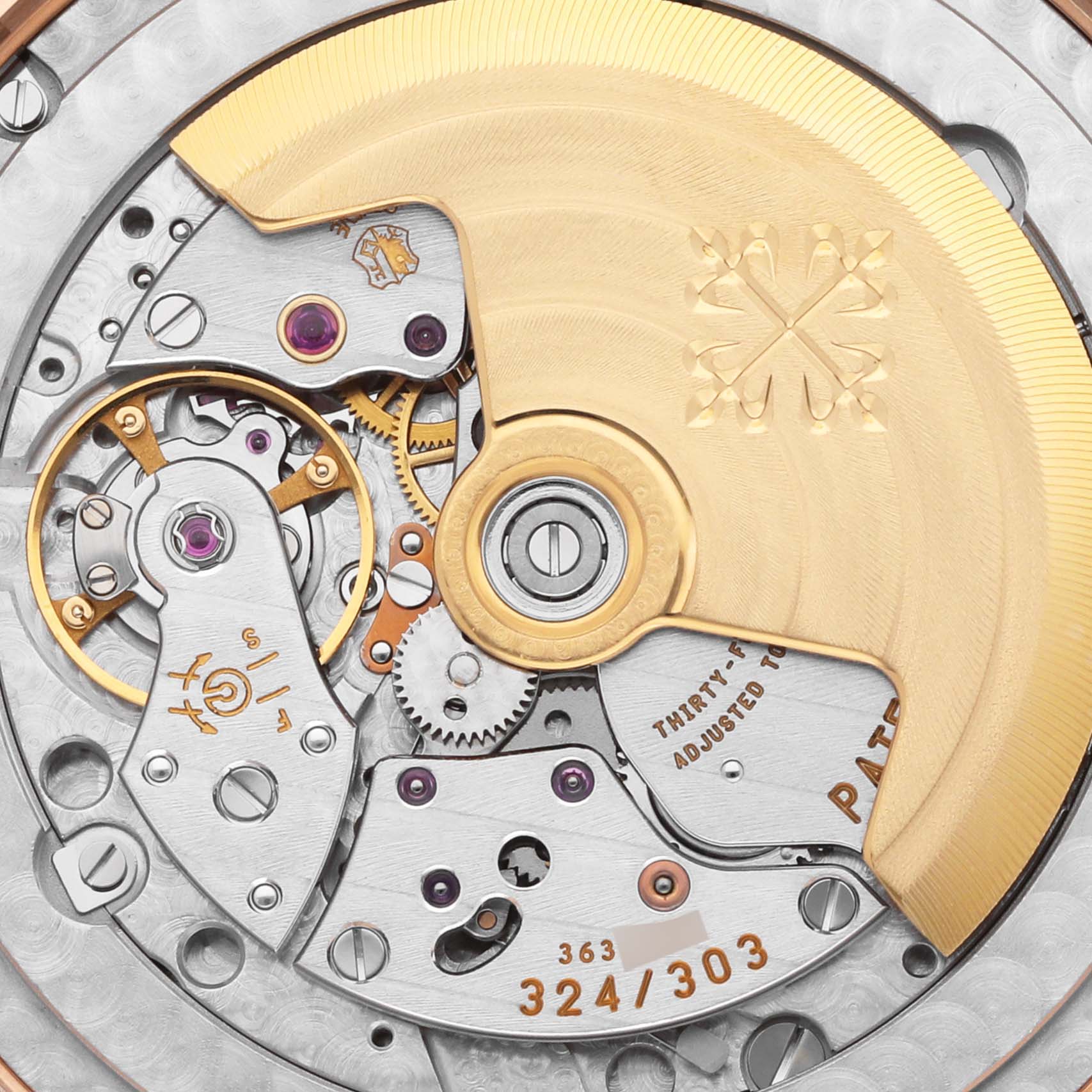 The image shows a close-up of the movement of a Patek Philippe Complications 5396R-001 Men's Rose Gold Silver Dial 5396R-001 Men's Rose Gold Silver Dial watch, highlighting gears and the rotor.
