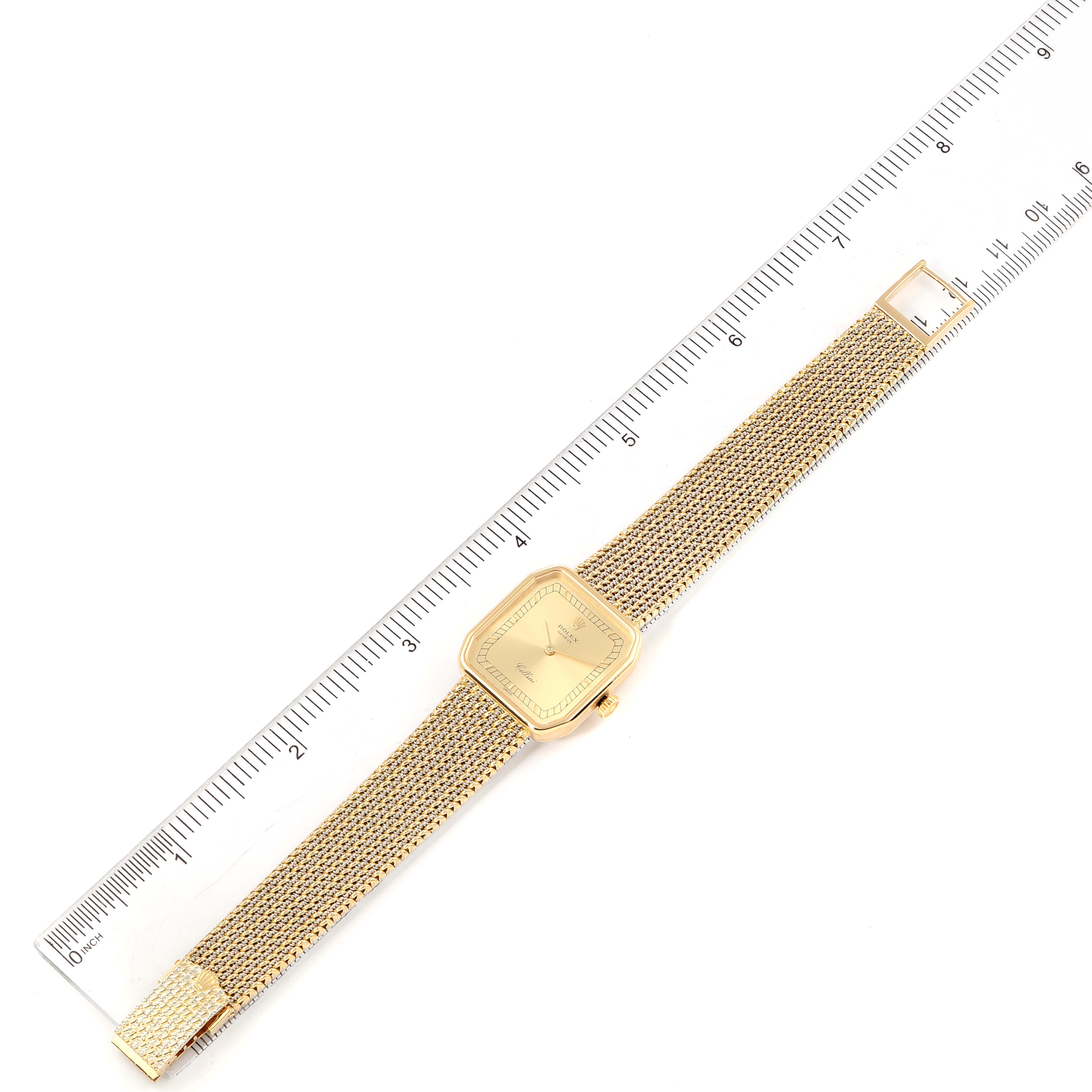 The Rolex Cellini 4347 Women's Yellow Gold Champagne Dial 4347 Women's Yellow Gold Champagne Dial watch is shown from a top-down angle, with its bracelet extended, next to a ruler.