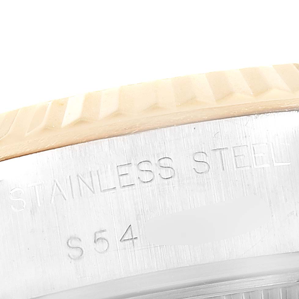 This image shows a close-up of the stainless steel side of a Rolex Datejust 69173 Women's Steel and Gold (two tone) Champagne Dial 69173 Women's Steel and Gold (two tone) Champagne Dial watch, displaying the case engraving and part of the fluted bezel.