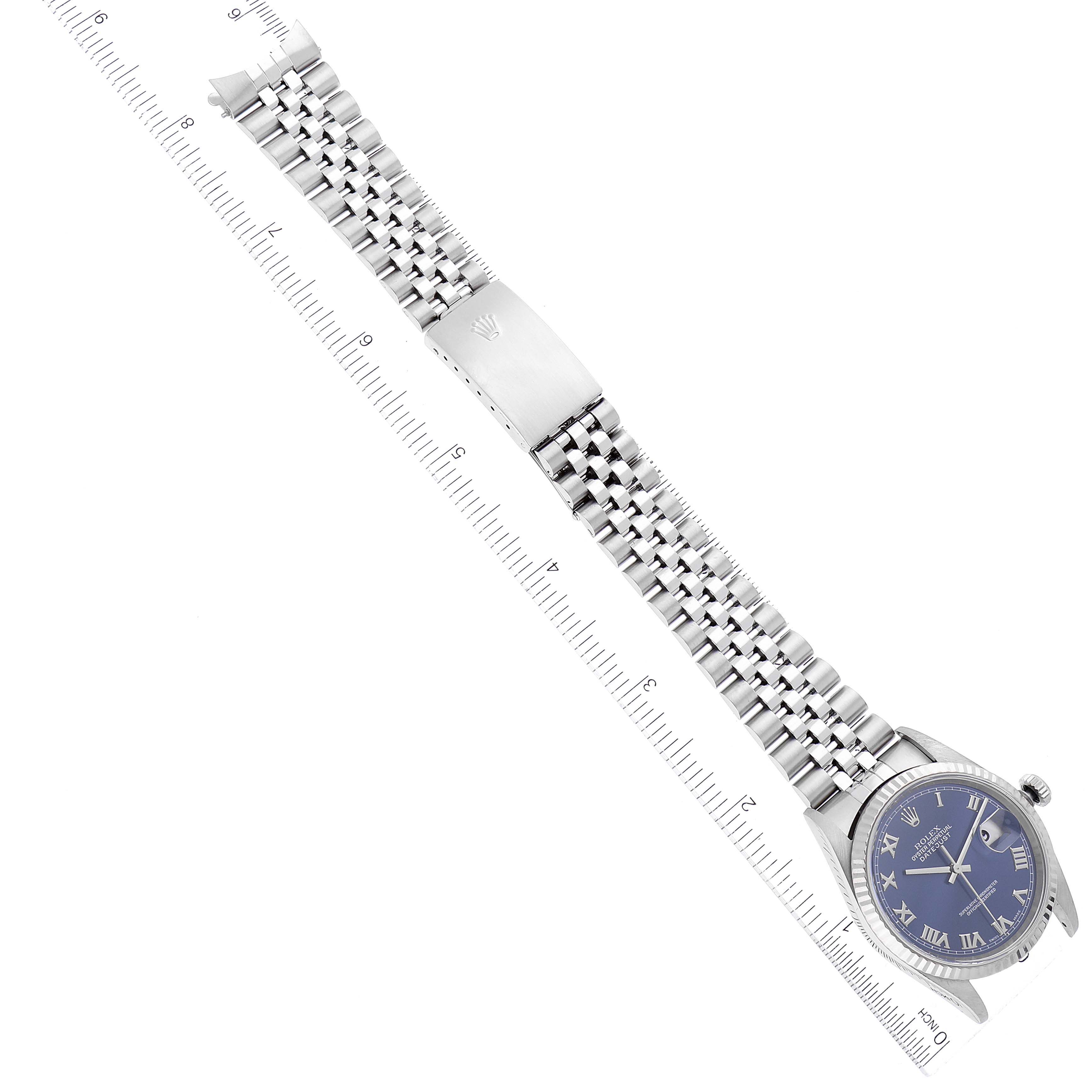 The image shows a Rolex Datejust 16234 Men's Stainless Steel Blue Dial 16234 Men's Stainless Steel Blue Dial watch laid flat at a slight angle with its bracelet fully extended and aligned with a ruler.