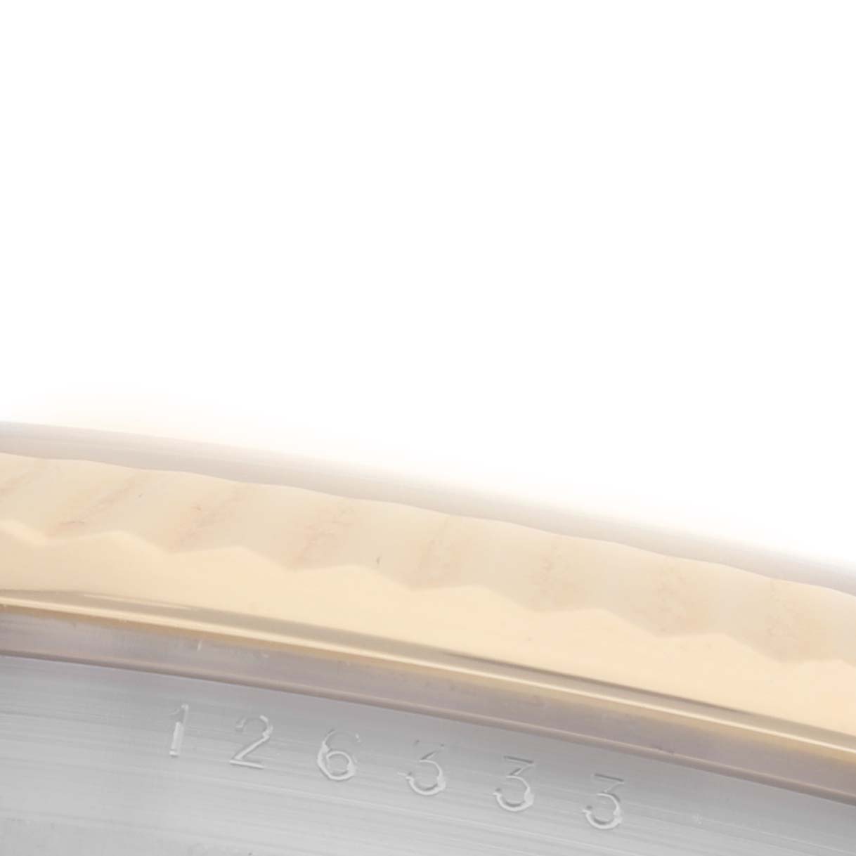 The image shows a partial view of the fluted bezel and engraved serial number of a Rolex Datejust 41 126333 Men's Steel and Gold (two tone) Black Dial 126333 Men's Steel and Gold (two tone) Black Dial watch.
