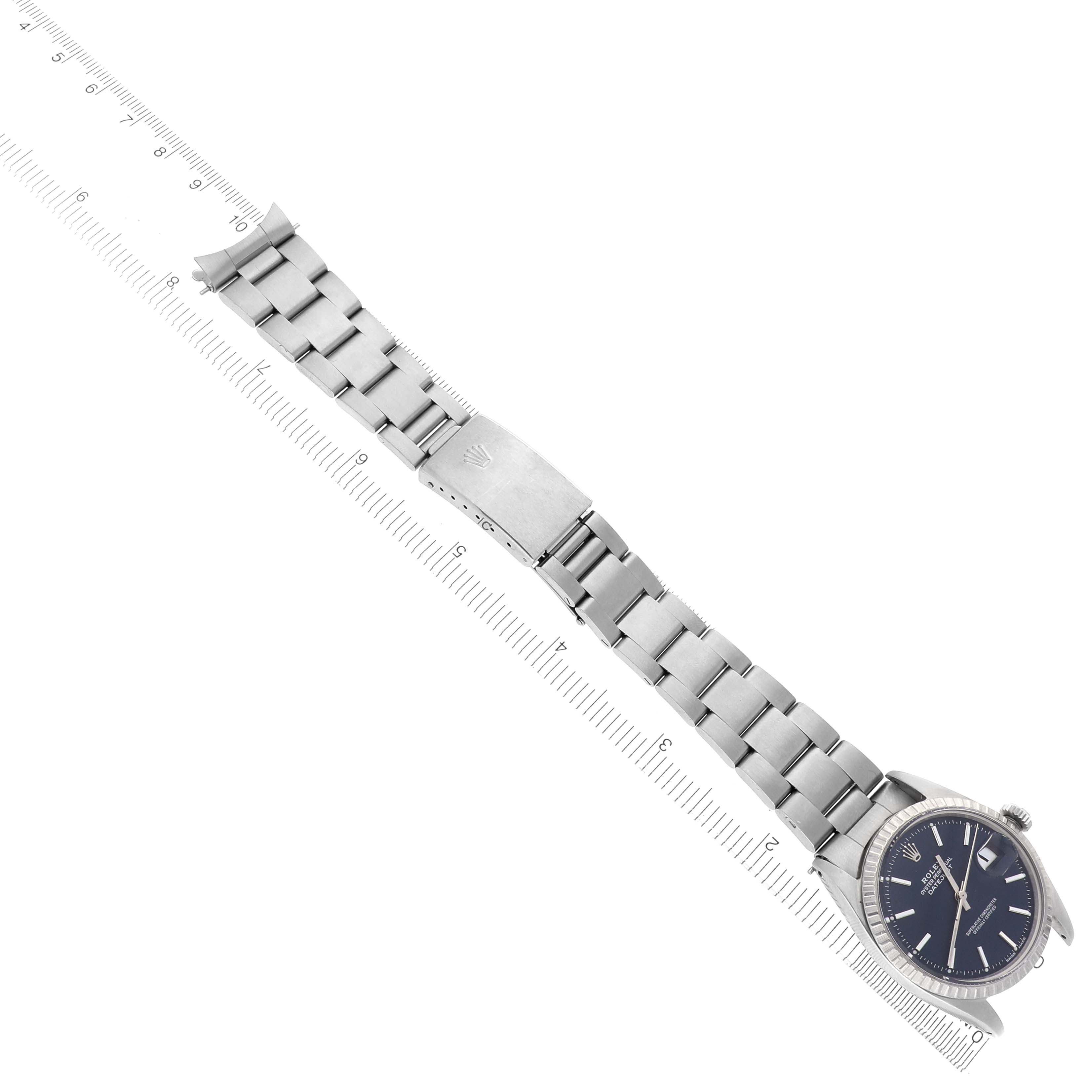 The image shows a Rolex Datejust 1603 Men's Stainless Steel Blue Dial 1603 Men's Stainless Steel Blue Dial watch at a diagonal angle, displaying the full bracelet, clasp, and dial against a ruler for scale.