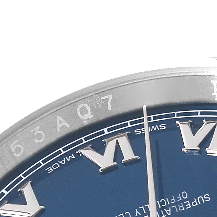 The image shows a close-up of the Rolex Datejust 116200 Men's Stainless Steel Blue Dial 116200 Men's Stainless Steel Blue Dial watch bezel, part of the dial with Roman numerals, and the minute hand.
