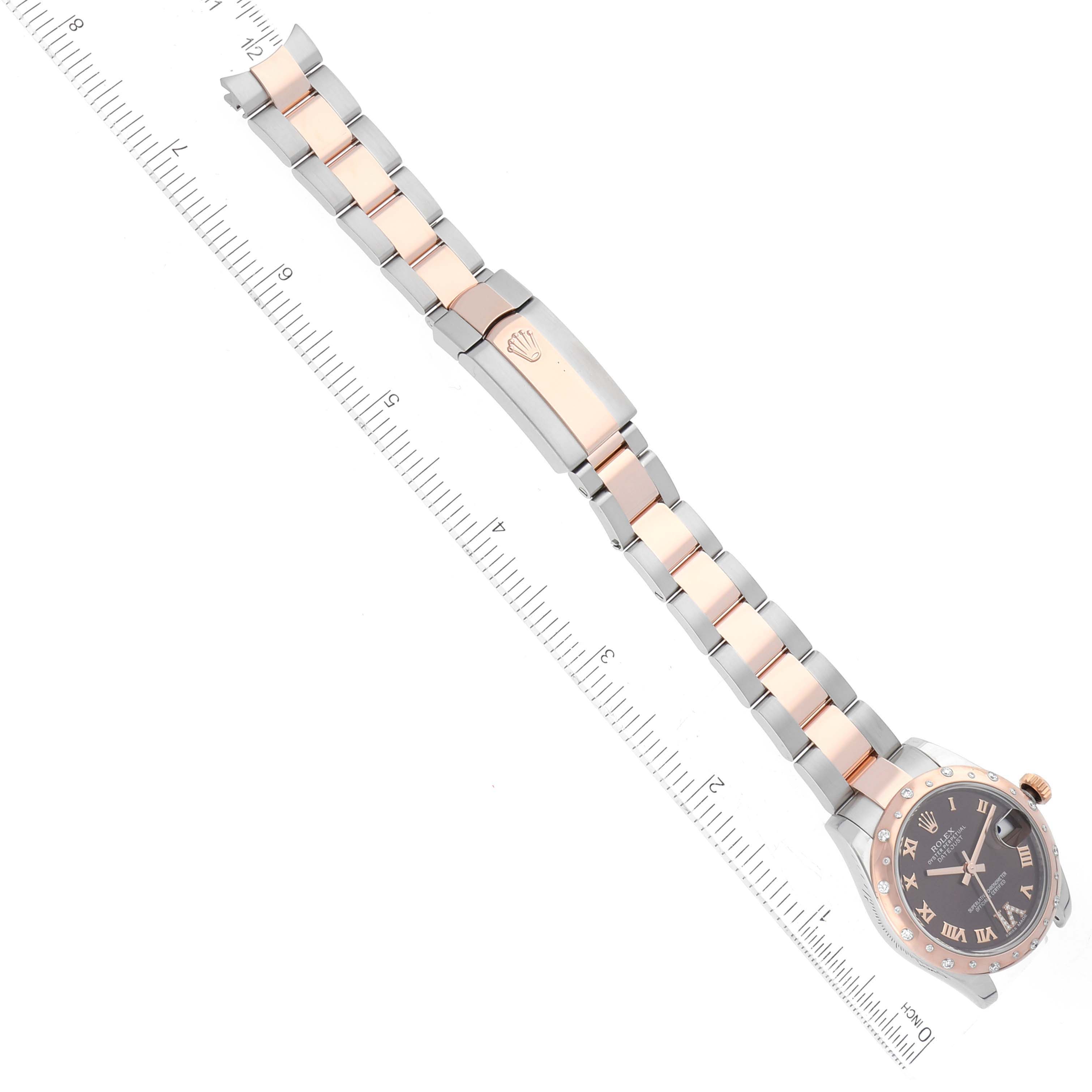 The image displays a Rolex Mid-Size 178341 Women's Steel and Gold (two tone) Brown Dial 178341 Women's Steel and Gold (two tone) Brown Dial watch laid flat with the bracelet extended, showing the dial and clasp against a ruler for scale.