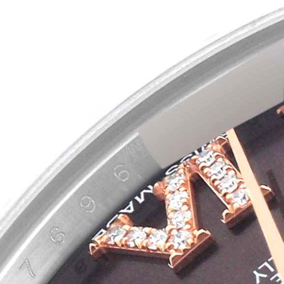 Close-up of the dial and bezel on a mid-size Rolex watch, showing hour markers and part of the numerals.