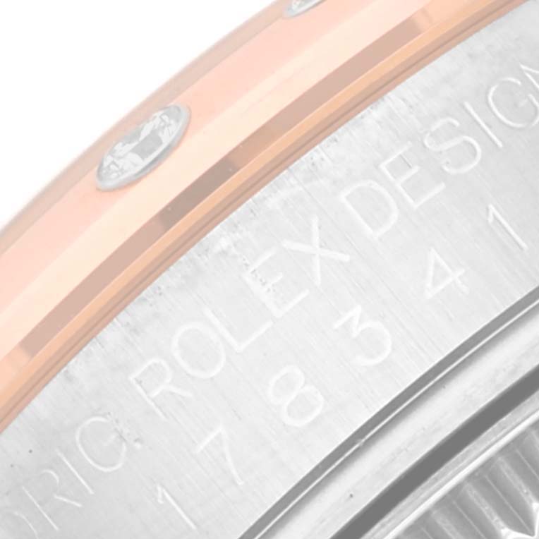 The image shows a close-up of the side engraving and part of the bezel of a Mid-Size Rolex watch.