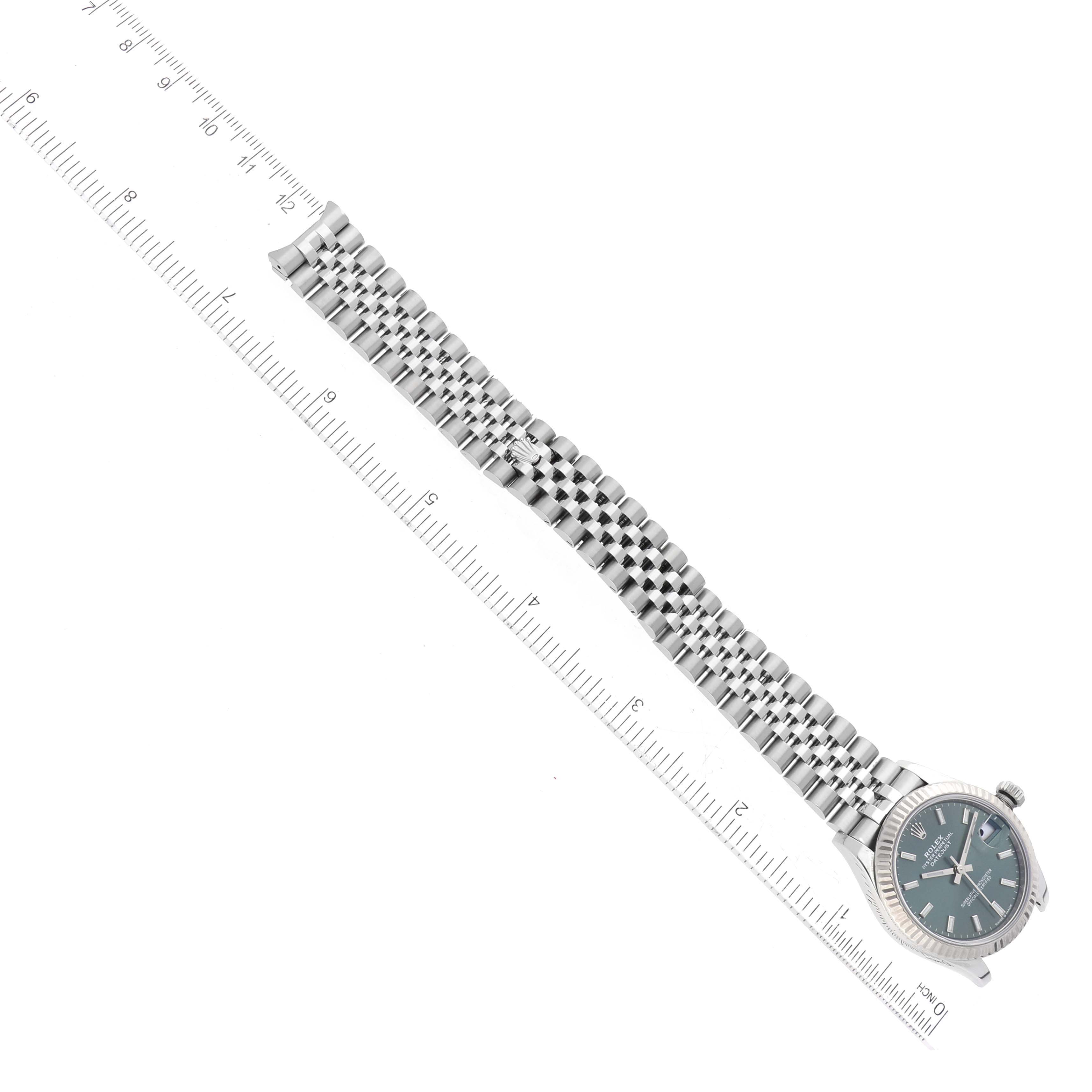 The image shows a top-down view of a Rolex Mid-Size 278274 Women's Stainless Steel Green Dial 278274 Women's Stainless Steel Green Dial watch with its full bracelet and a ruler for scale.