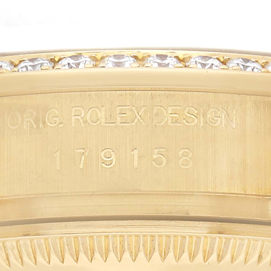 The image shows a partial side view of a Rolex President 179158 Women's Yellow Gold Mother of Pearl Dial 179158 Women's Yellow Gold Mother of Pearl Dial model, focusing on the bezel with embedded diamonds and engraved model number.
