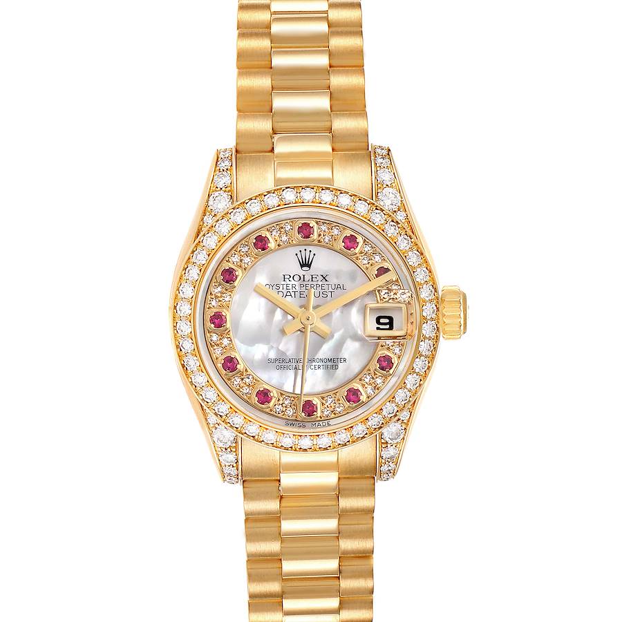 The Rolex President model watch is shown from a top-down angle, highlighting its diamond and ruby-encrusted bezel, face, and gold bracelet.