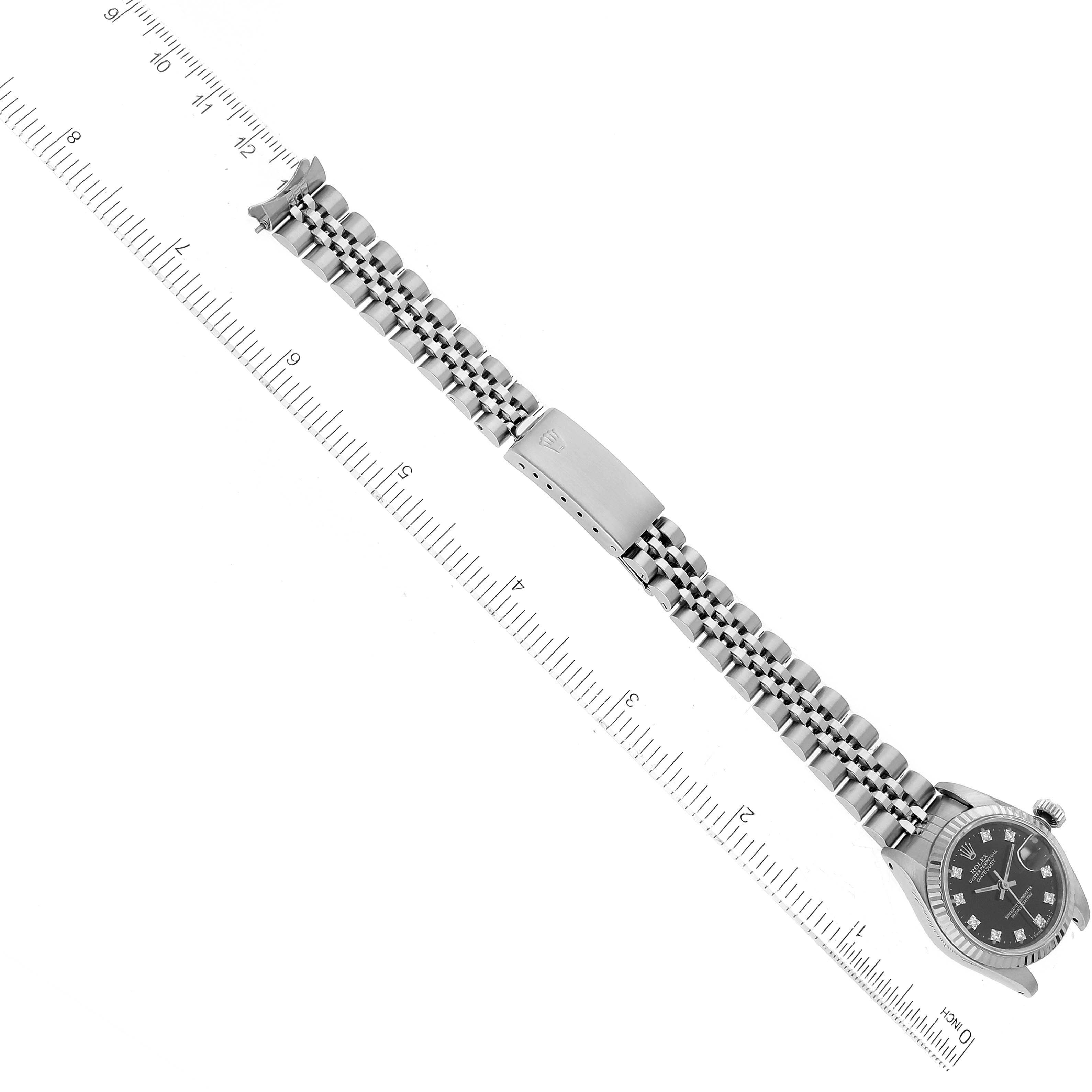 The image shows a Rolex Datejust 69174 Women's Stainless Steel Black Dial 69174 Women's Stainless Steel Black Dial watch from a top-down angle, displaying the watch face, band, and clasp alongside a measuring ruler.