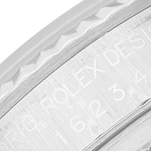This close-up image of a Rolex Datejust 16234 Men's Stainless Steel Blue Dial 16234 Men's Stainless Steel Blue Dial watch shows part of the watch bezel and engraved text on the inner ring.