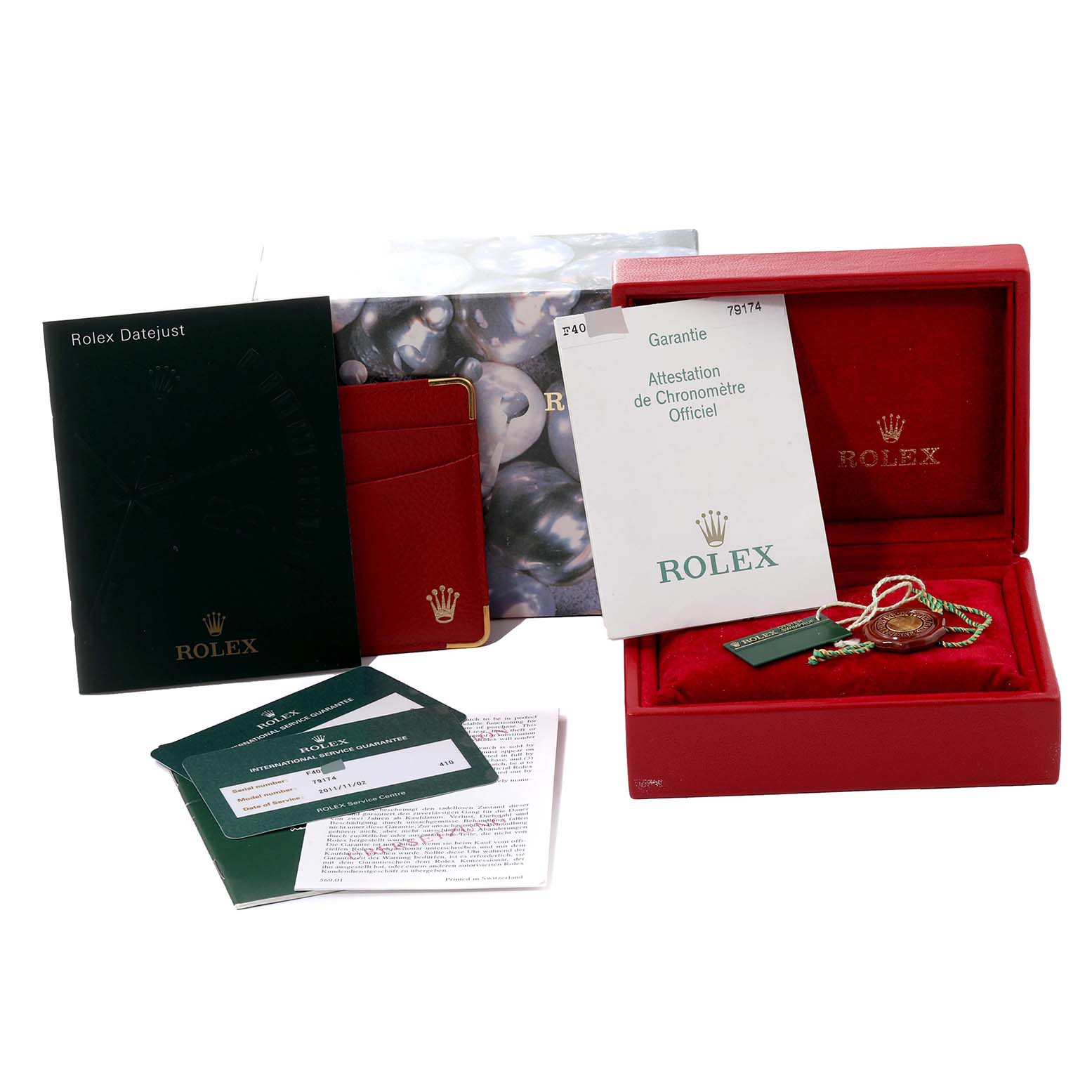 The image shows accessories of the Rolex Datejust 79174 Women's Stainless Steel Mother of Pearl Dial 79174 Women's Stainless Steel Mother of Pearl Dial model, including booklets, a red box, tags, and warranty documents.