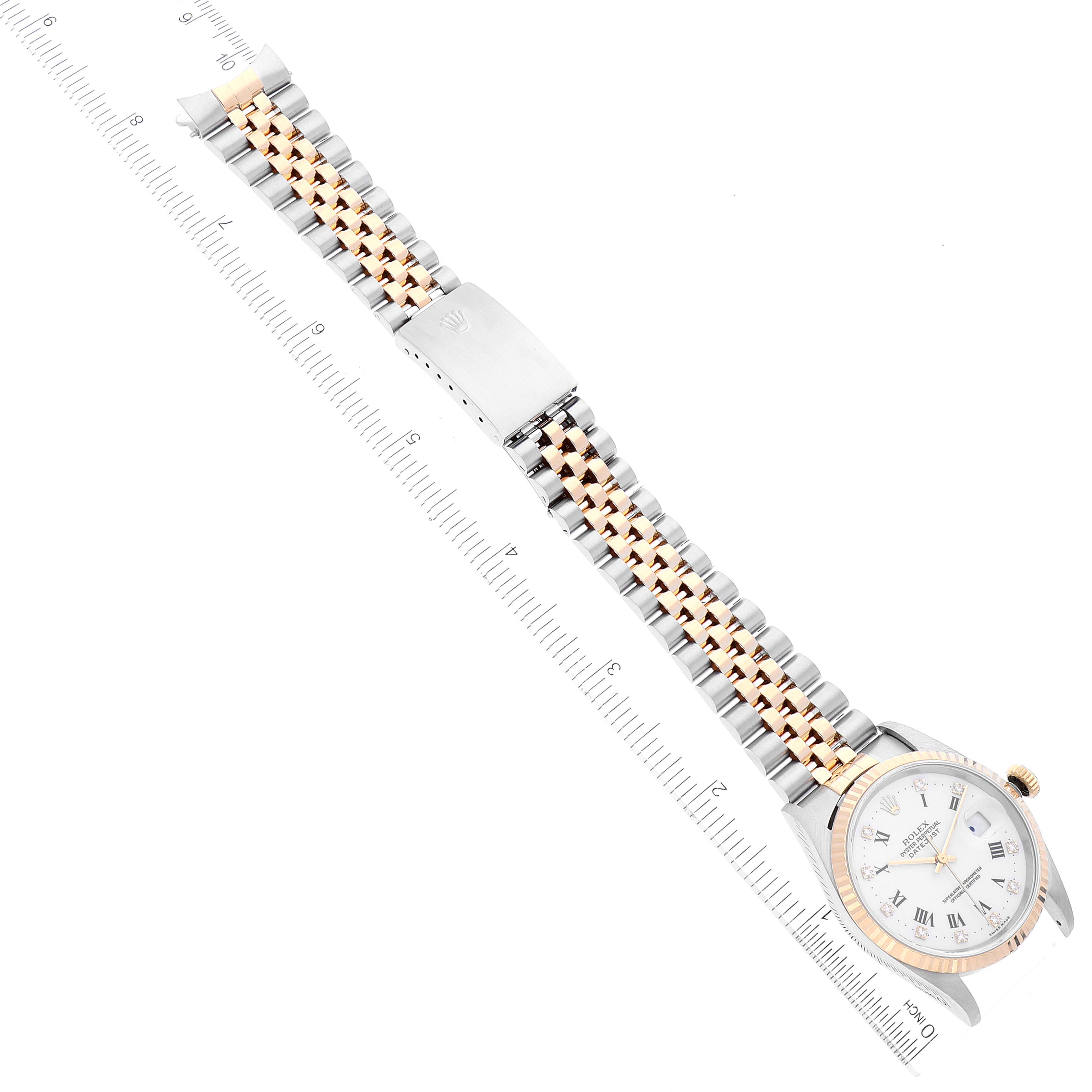 The image shows a top-down view of a Rolex Datejust 16233 Men's Steel and Gold (two tone) White Dial 16233 Men's Steel and Gold (two tone) White Dial watch featuring a two-tone bracelet and part of a ruler.