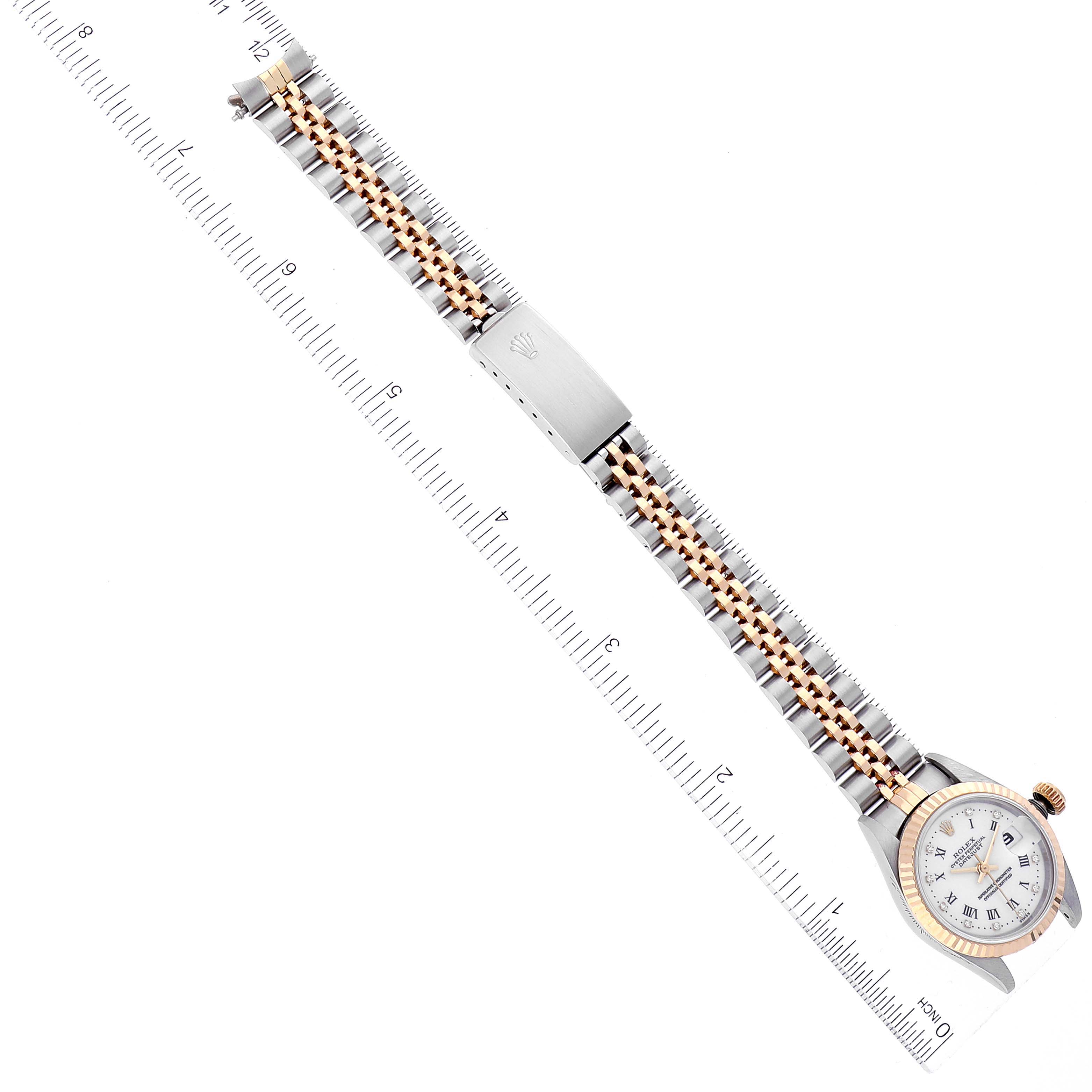 This image shows a top view of the Rolex Datejust 69173 Women's Steel and Gold (two tone) White Dial 69173 Women's Steel and Gold (two tone) White Dial watch, showcasing the watch face, bezel, and dual-tone bracelet alongside a ruler for scale.