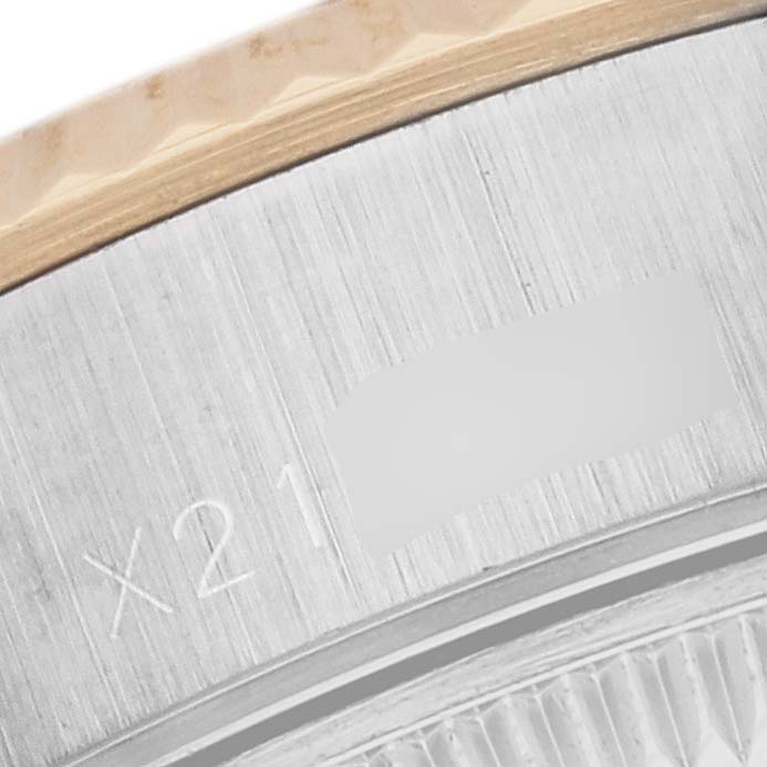 This image shows a close-up of the bezel and part of the case with an inscription on a Rolex Datejust 69173 Women's Steel and Gold (two tone) White Dial 69173 Women's Steel and Gold (two tone) White Dial watch.
