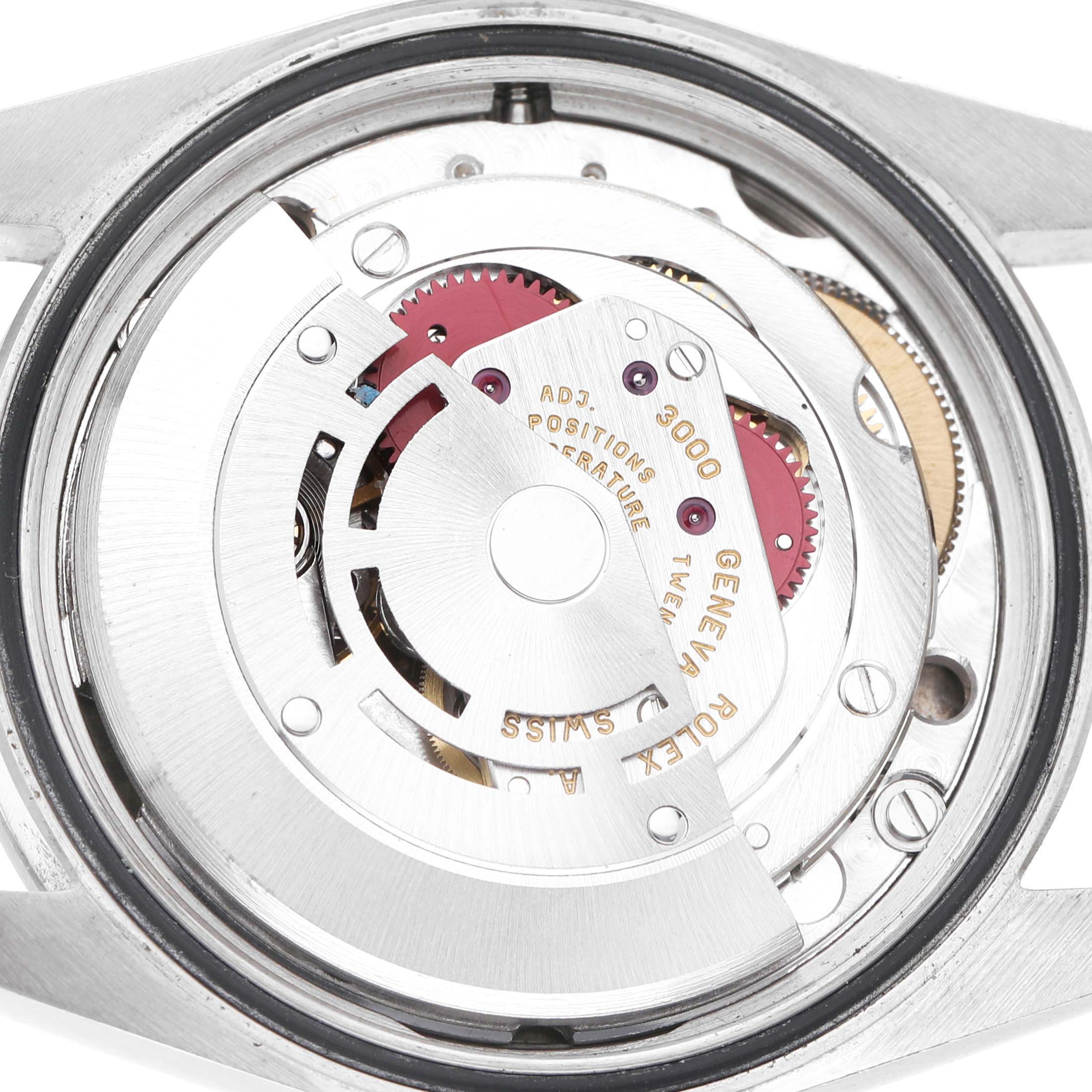 The image shows a close-up of the movement of a Rolex Explorer 114270 Men's Stainless Steel Black Dial watch, featuring gears and the engraved rotor.