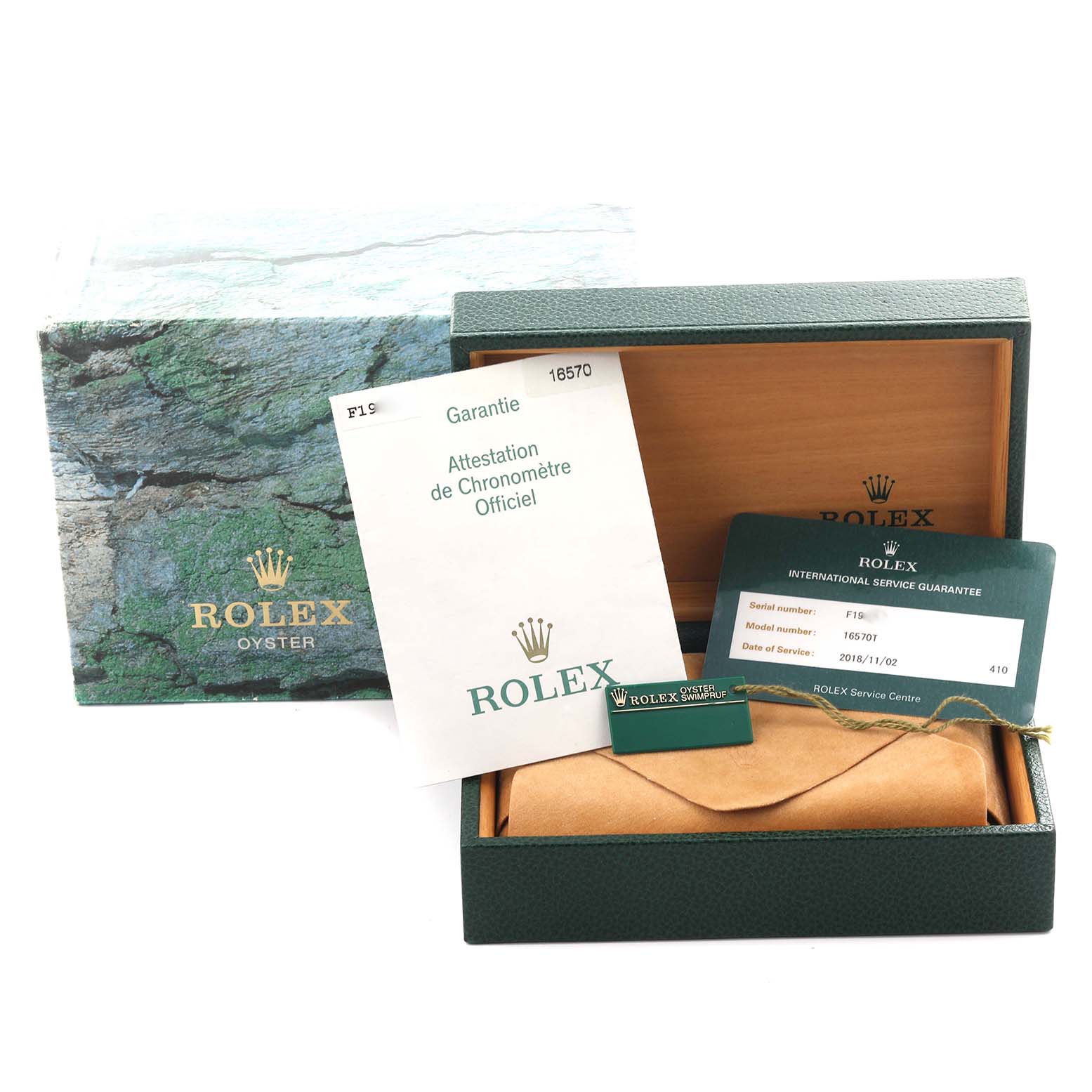 The image shows a Rolex Explorer 16570T Men
s Stainless Steel Black Dial 16570T Men
s Stainless Steel Black Dial watch box, international service guarantee, and related documents from a top-down angle.