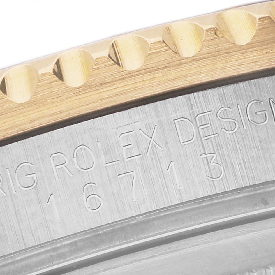 The image shows a close-up of the engraved metal back and bezel edge of a Rolex GMT-Master 16713 Men's Steel and Gold (two tone) Brown Dial 16713 Men's Steel and Gold (two tone) Brown Dial watch.