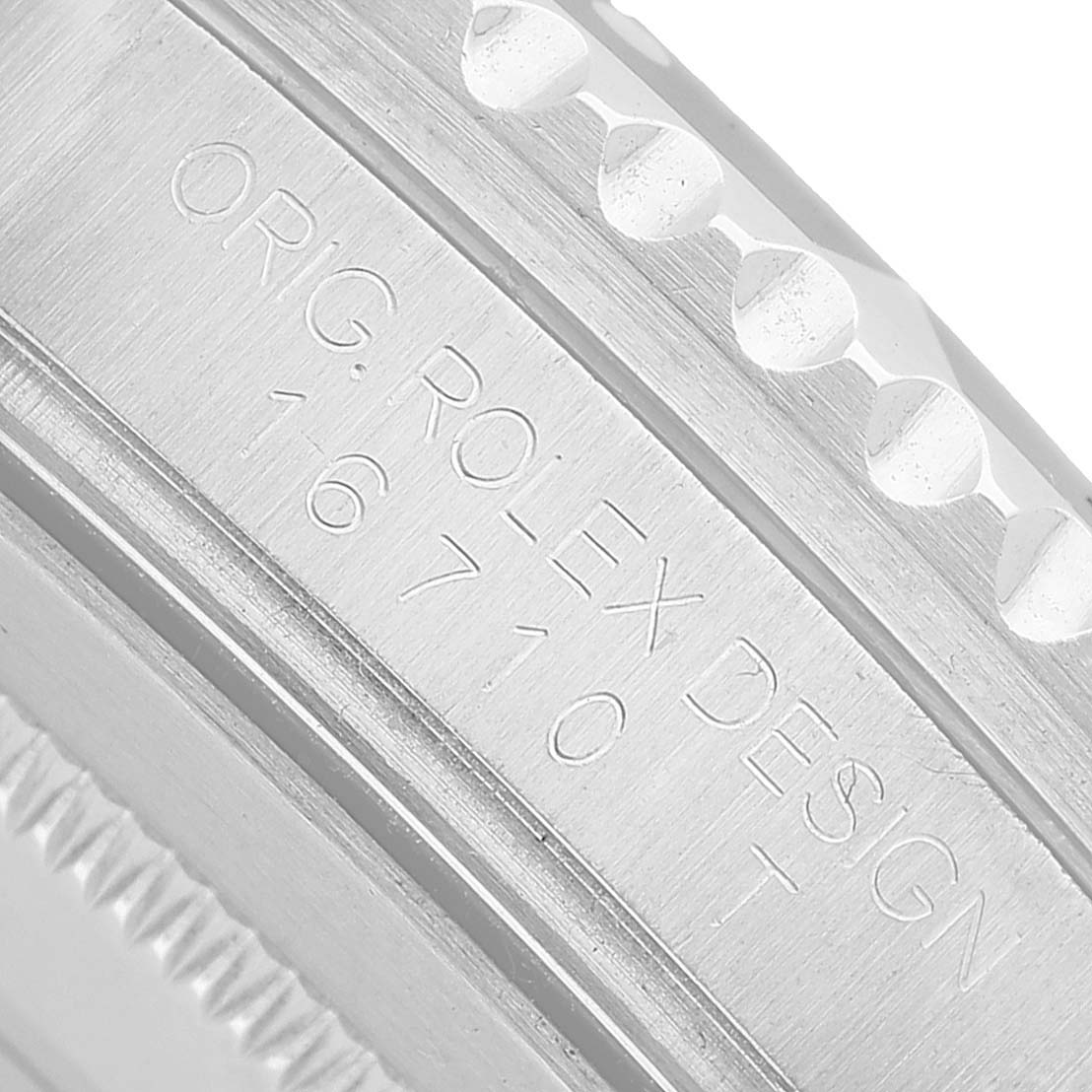 The image shows a close-up of the side engraving on a Rolex GMT-Master 16710 Men's Stainless Steel Black Dial watch bezel.