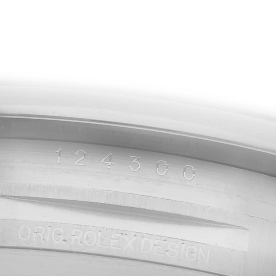 The image shows an interior view of the Rolex Oyster Perpetual 124300 Men's Stainless Steel Silver Dial 124300 Men's Stainless Steel Silver Dial's watch case with engraved details.