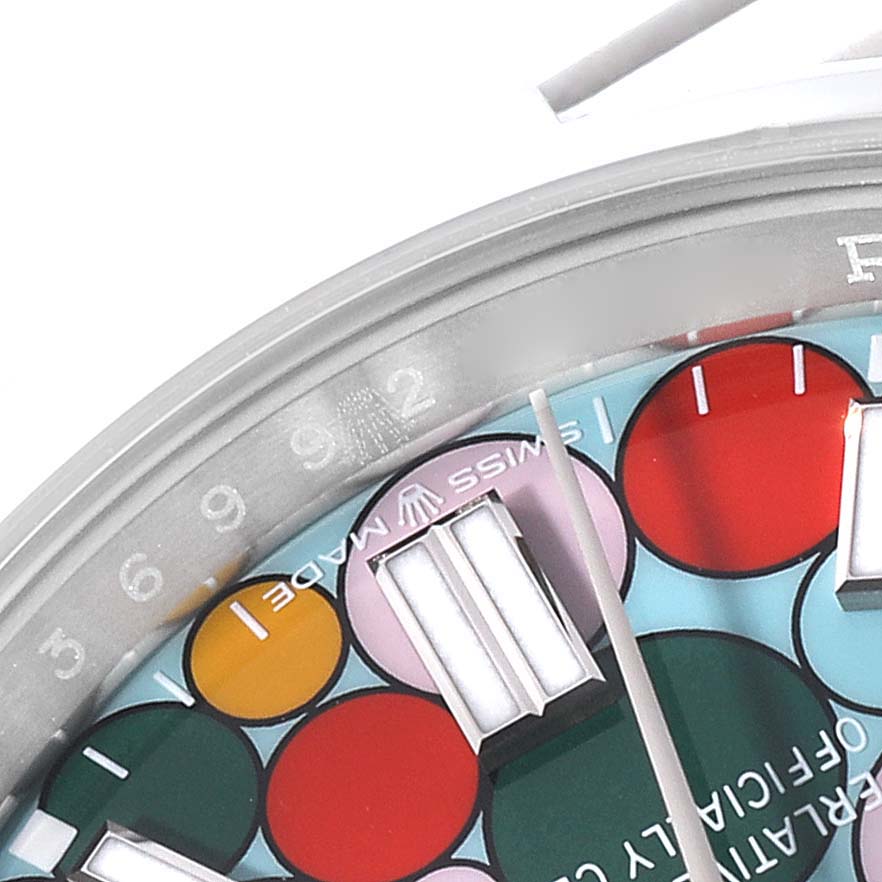 This image shows a close-up of the dial and part of the bezel of a Rolex Oyster Perpetual 126000 Men
s Stainless Steel Blue Dial 126000 Men
s Stainless Steel Blue Dial watch with a colorful pattern design.