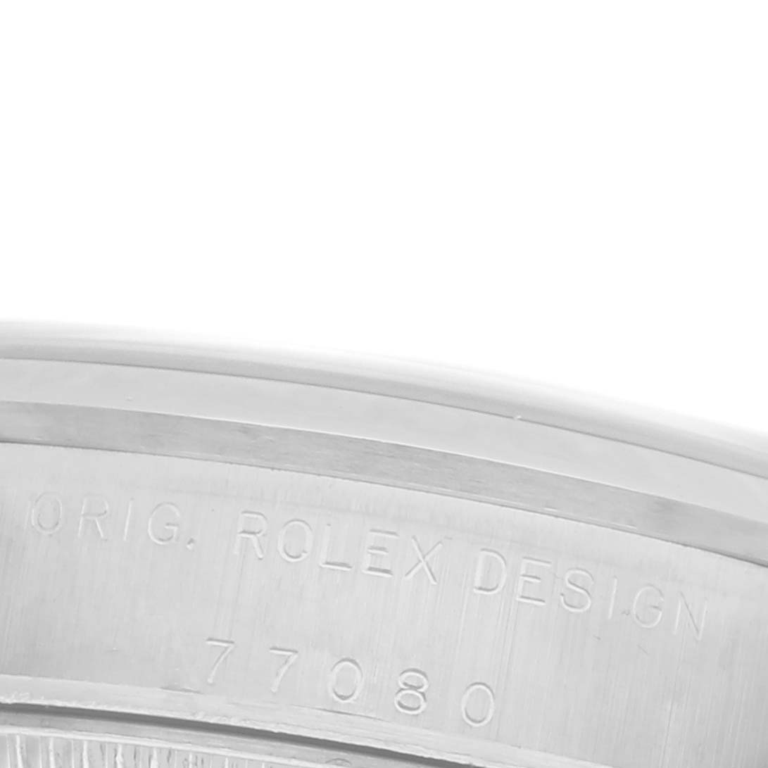 The image shows the side of a Rolex Mid-Size 77080 Women's Stainless Steel Silver Dial 77080 Women's Stainless Steel Silver Dial watch case with engraving details.